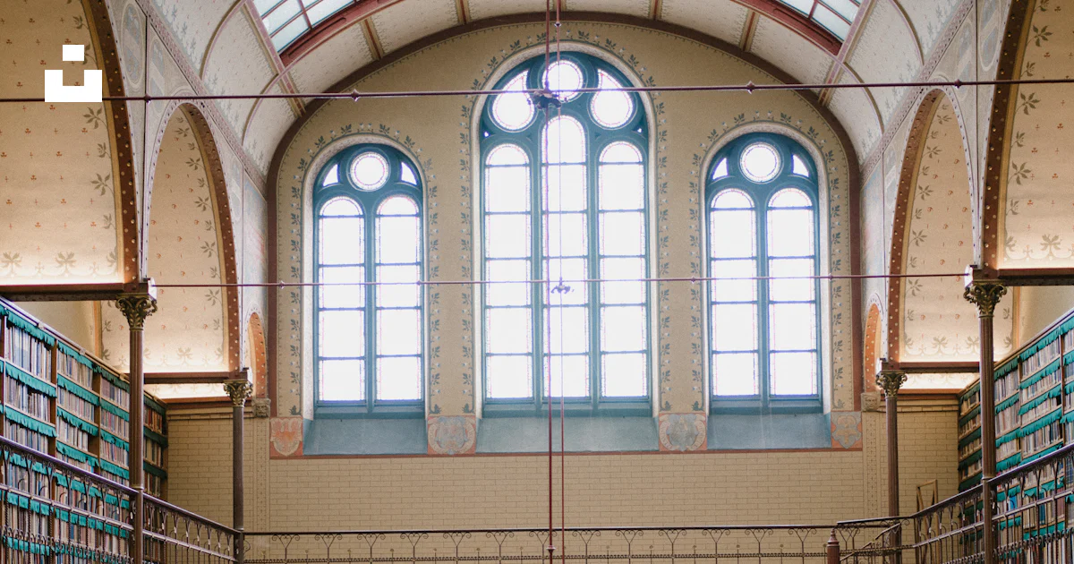 Grand library interior with tall bookshelves and arched windows photo ...