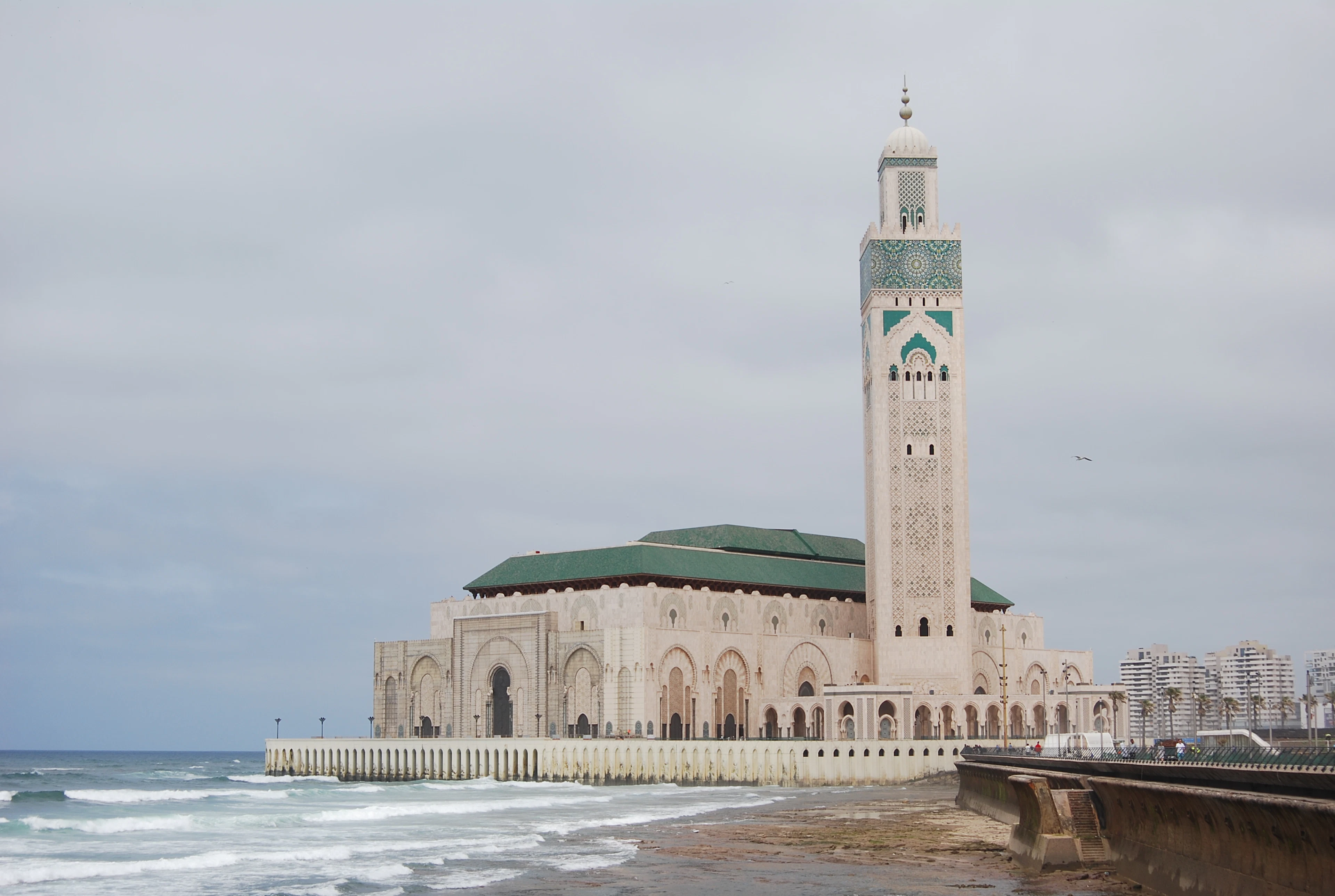 The Hassan II Mosque in Casablanca beside the ocean on a cloudy day