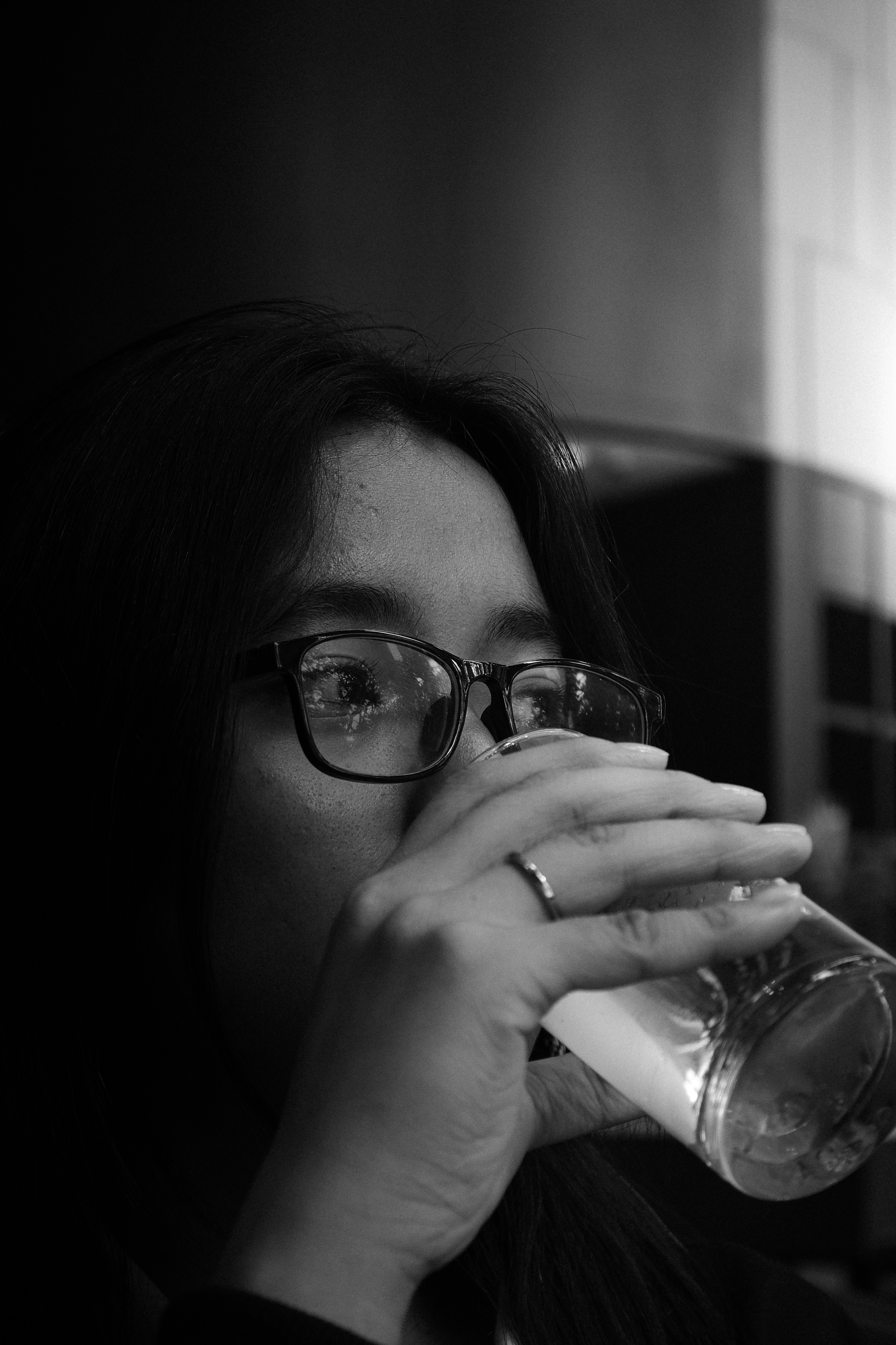 Woman wearing glasses drinks from a glass