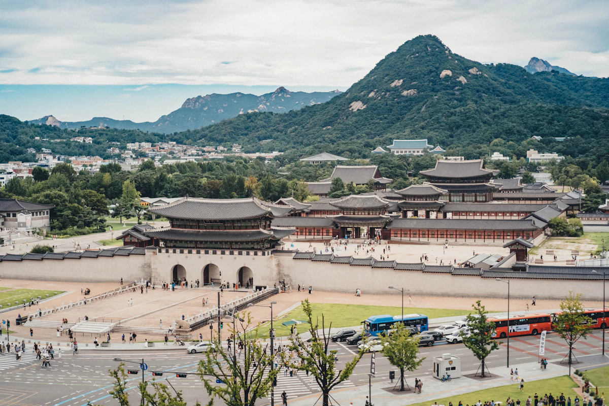 Historic palace complex with mountains in the background.