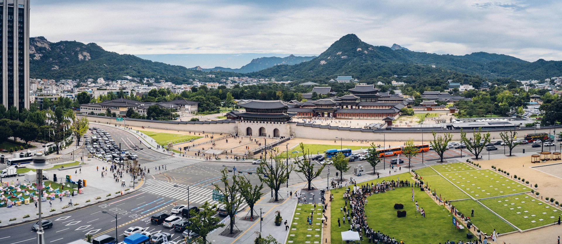 Gyeongbokgung Palace's stone gate with Bugaksan mountain rising behind it under a blue sky