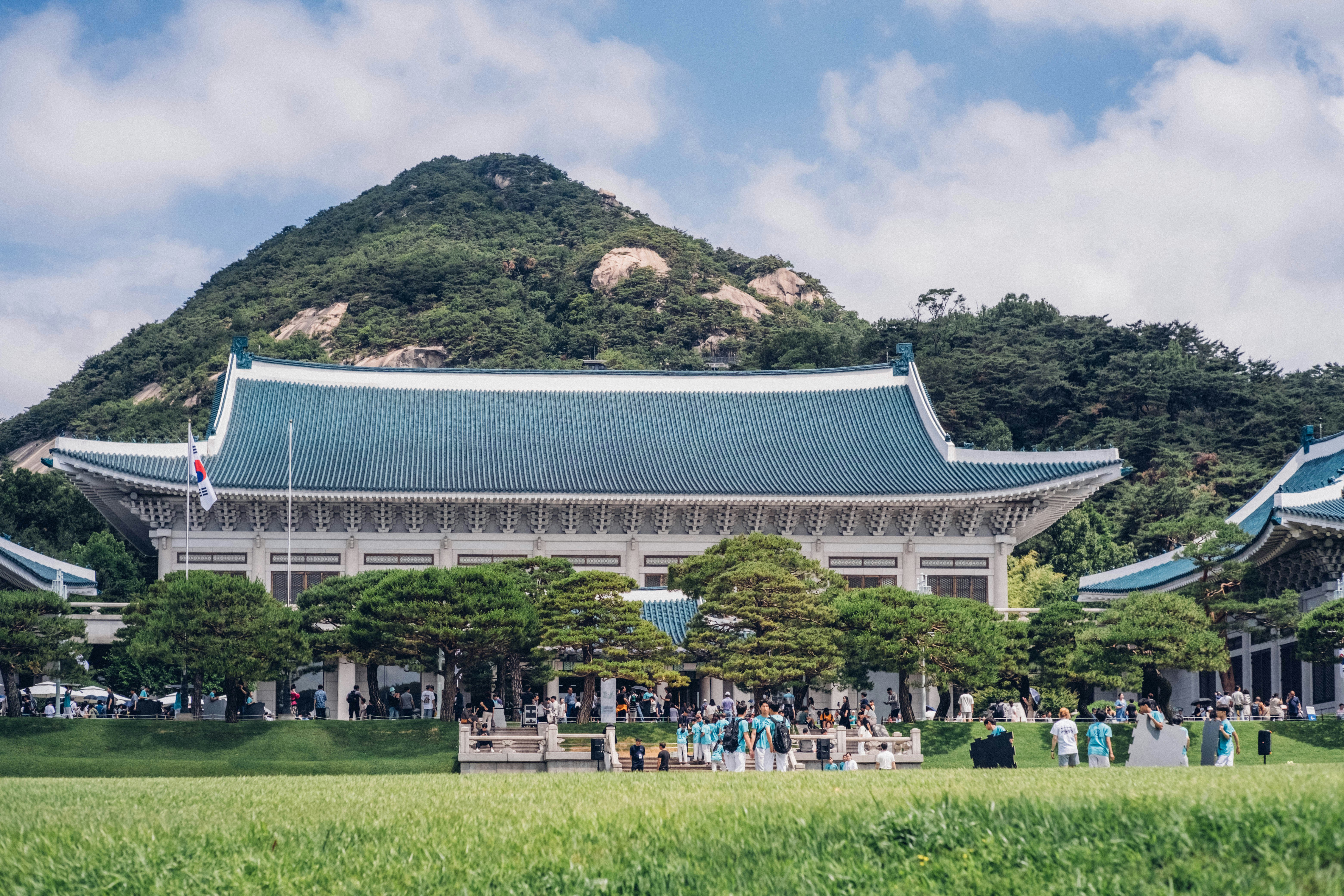 Blue-roofed building with a mountain behind it.