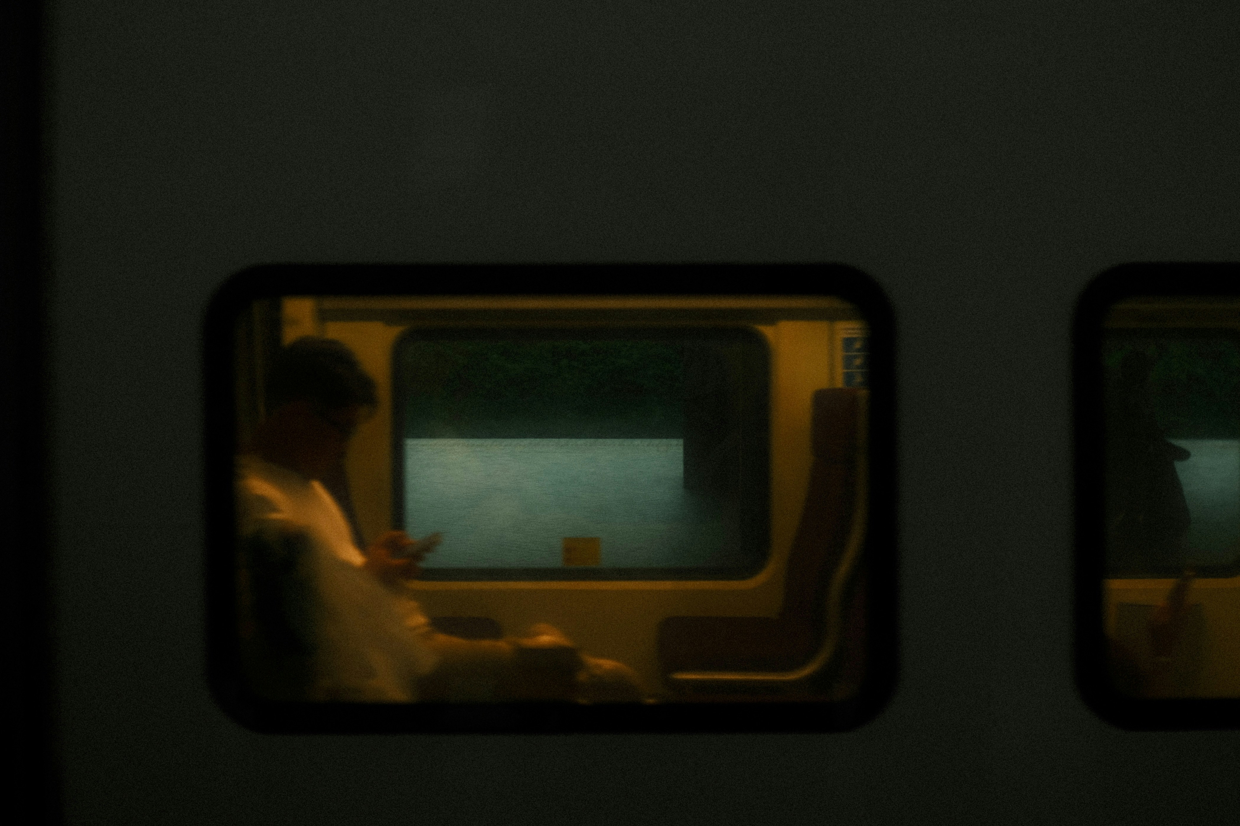 Man looking at phone inside a train at night