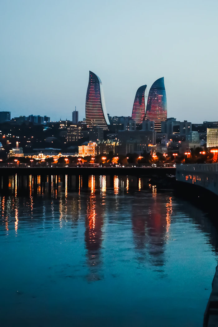 Baku's Flame Towers lit up over the water at dusk