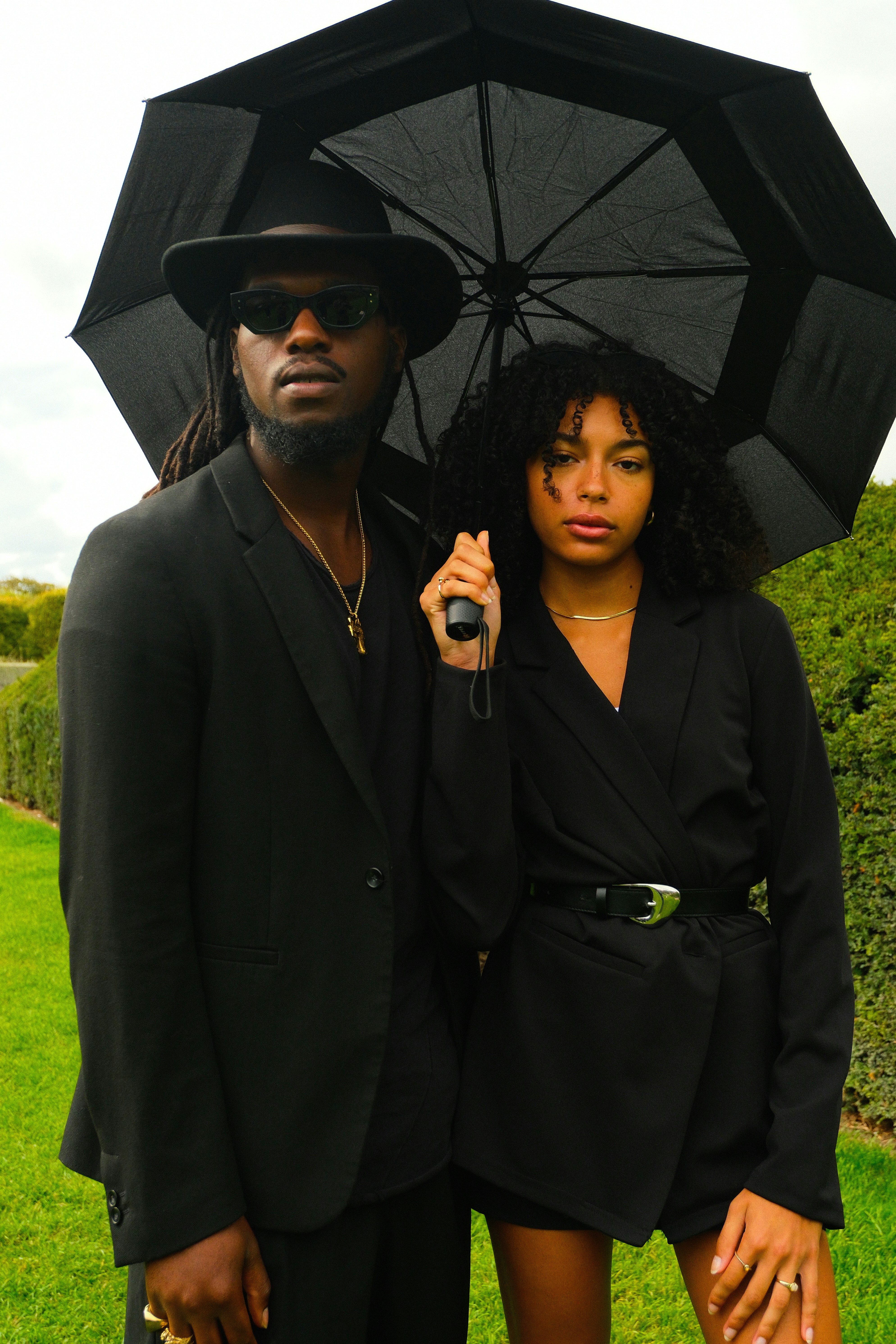 Couple in black attire under an umbrella outdoors