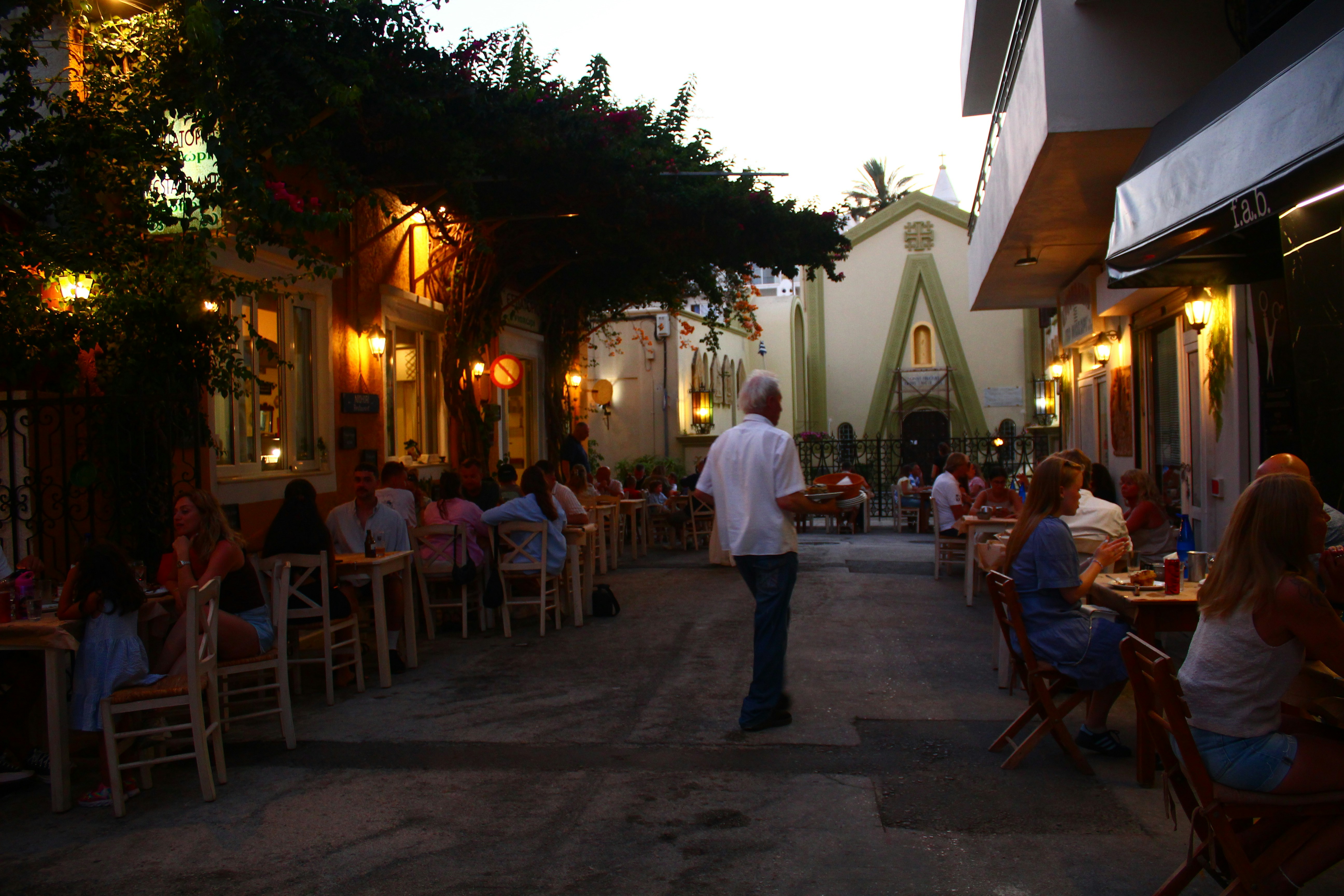 People dining at outdoor tables along a street