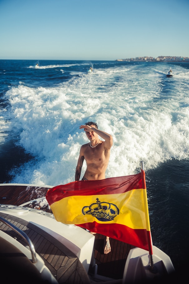 Man on boat with spanish flag enjoys ocean view