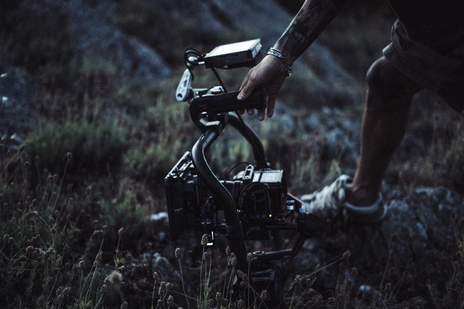 A videographer operating a professional cinema camera on a gimbal rig on location