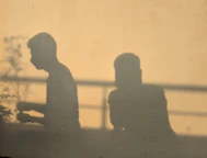 Silhouettes of two people against a warm background.