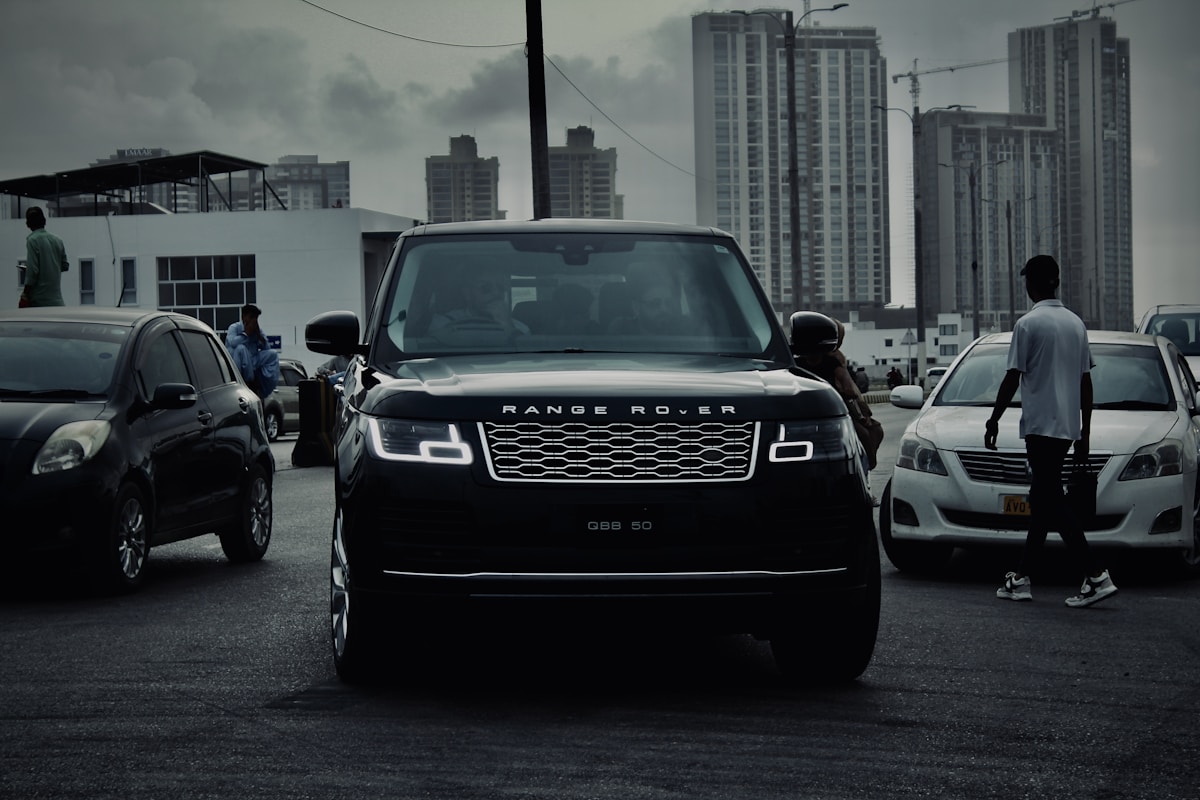 black range rover parked with city buildings background