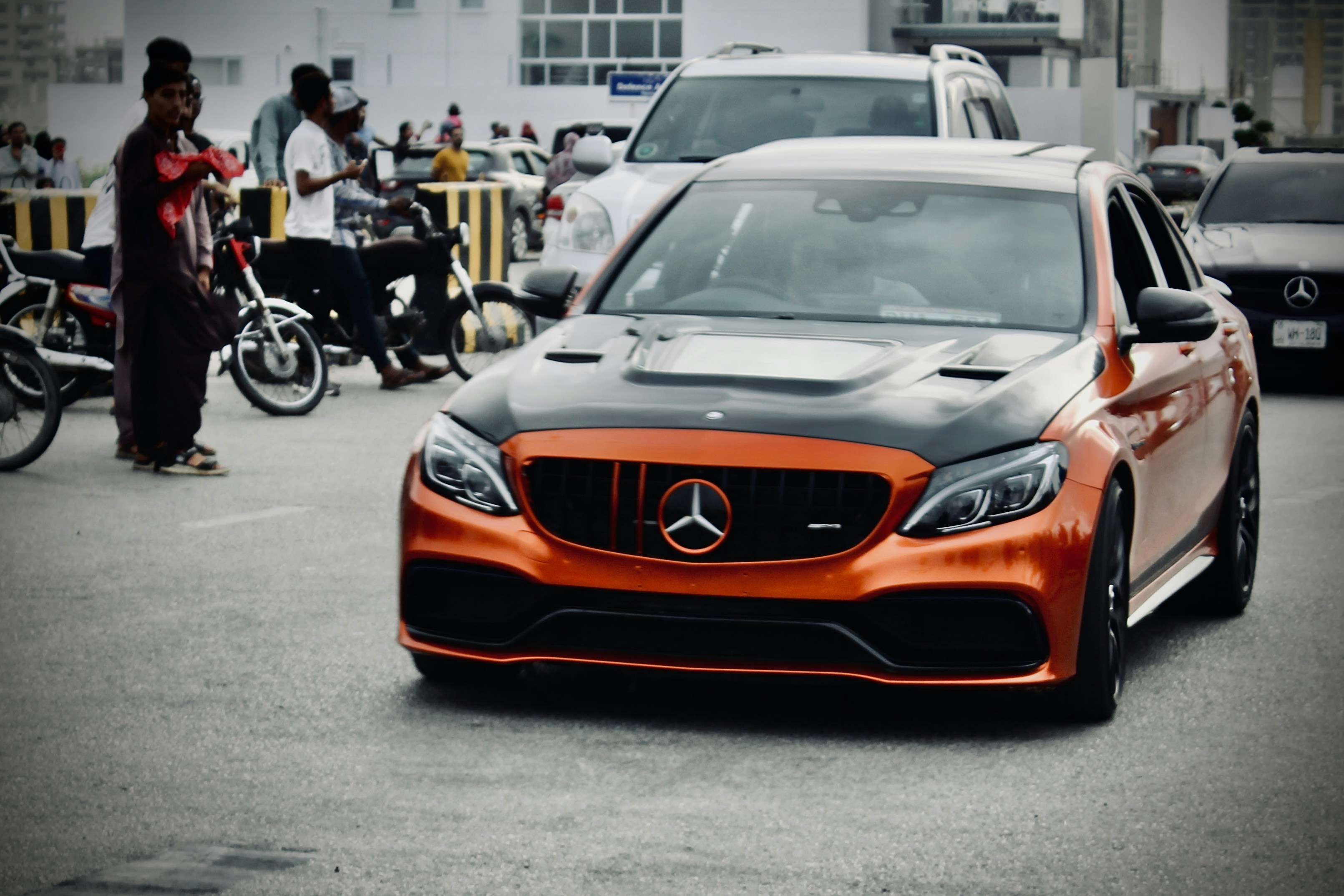 Orange Mercedes-Benz with black hood in motion
