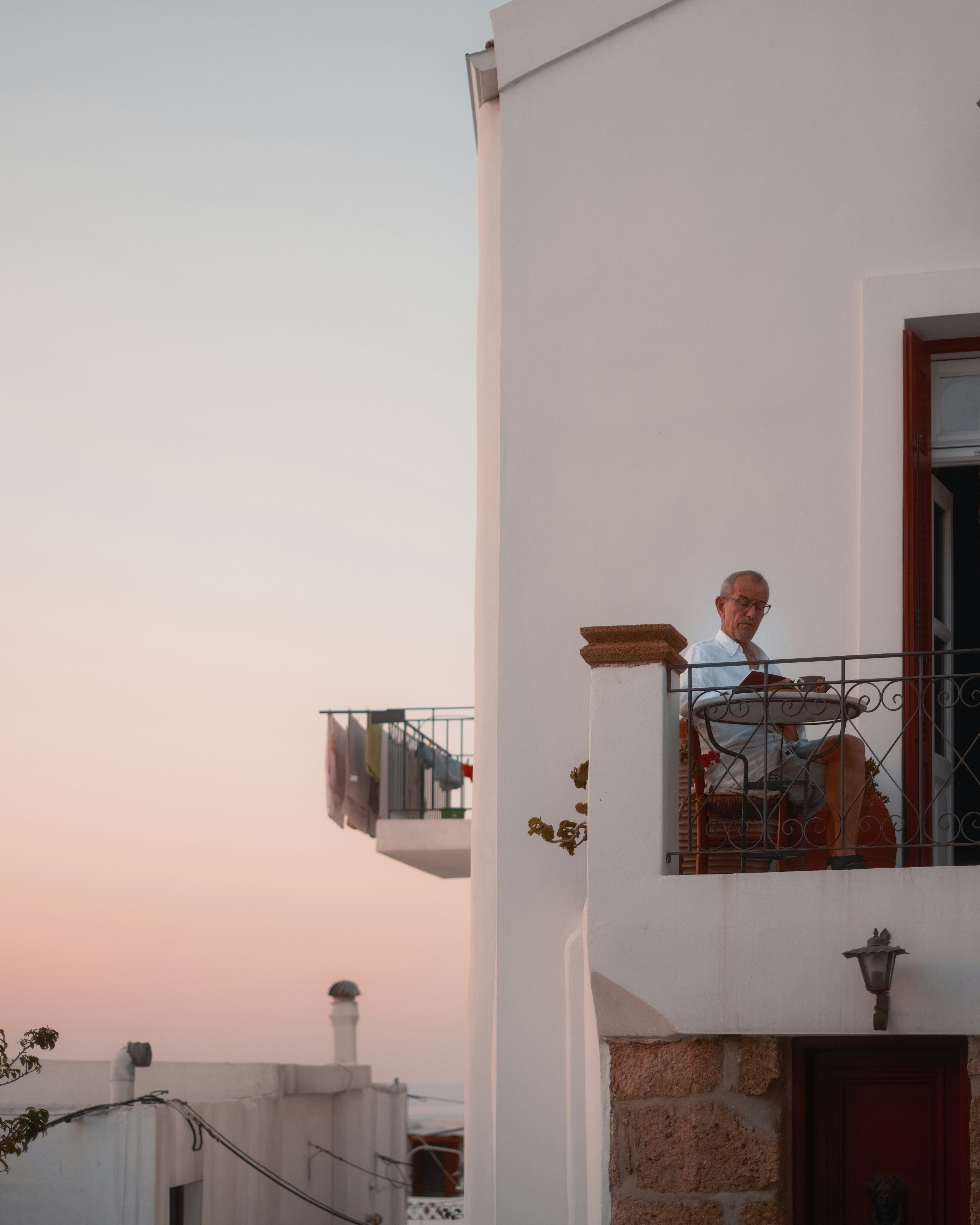 Man sitting on a balcony at sunset