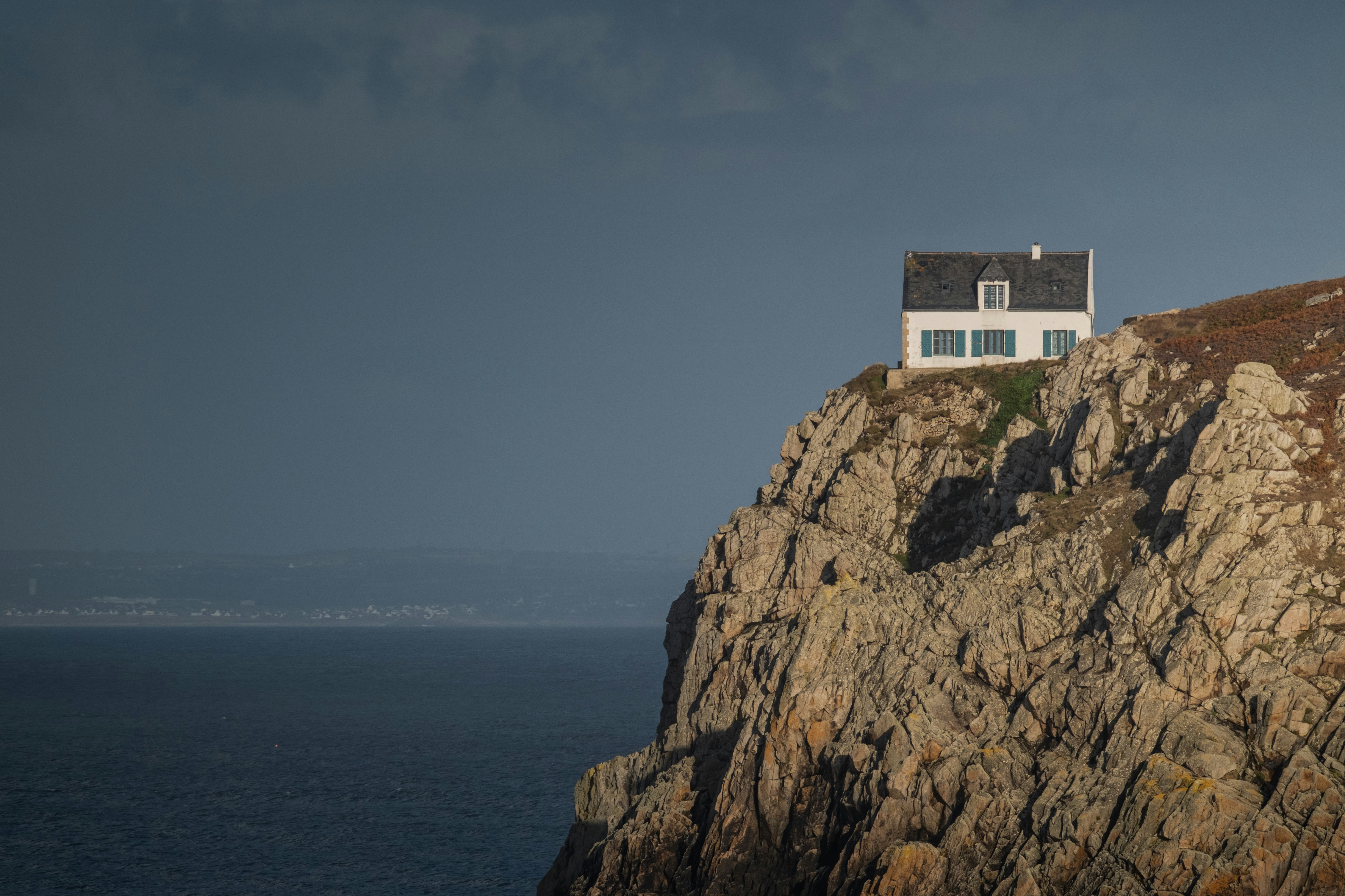 Casa bianca su una scogliera rocciosa che si affaccia sull'oceano