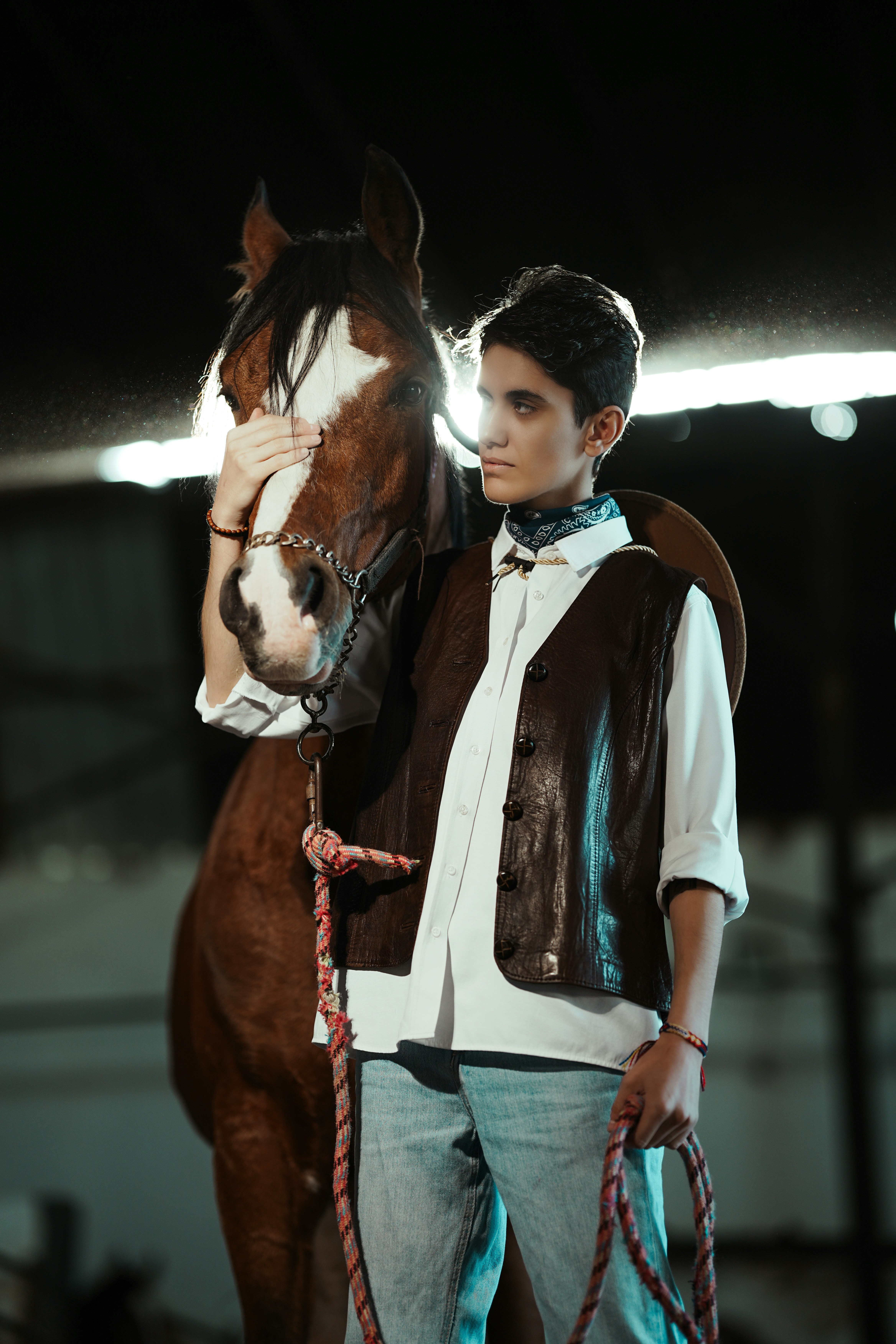 Young person in cowboy attire with a horse