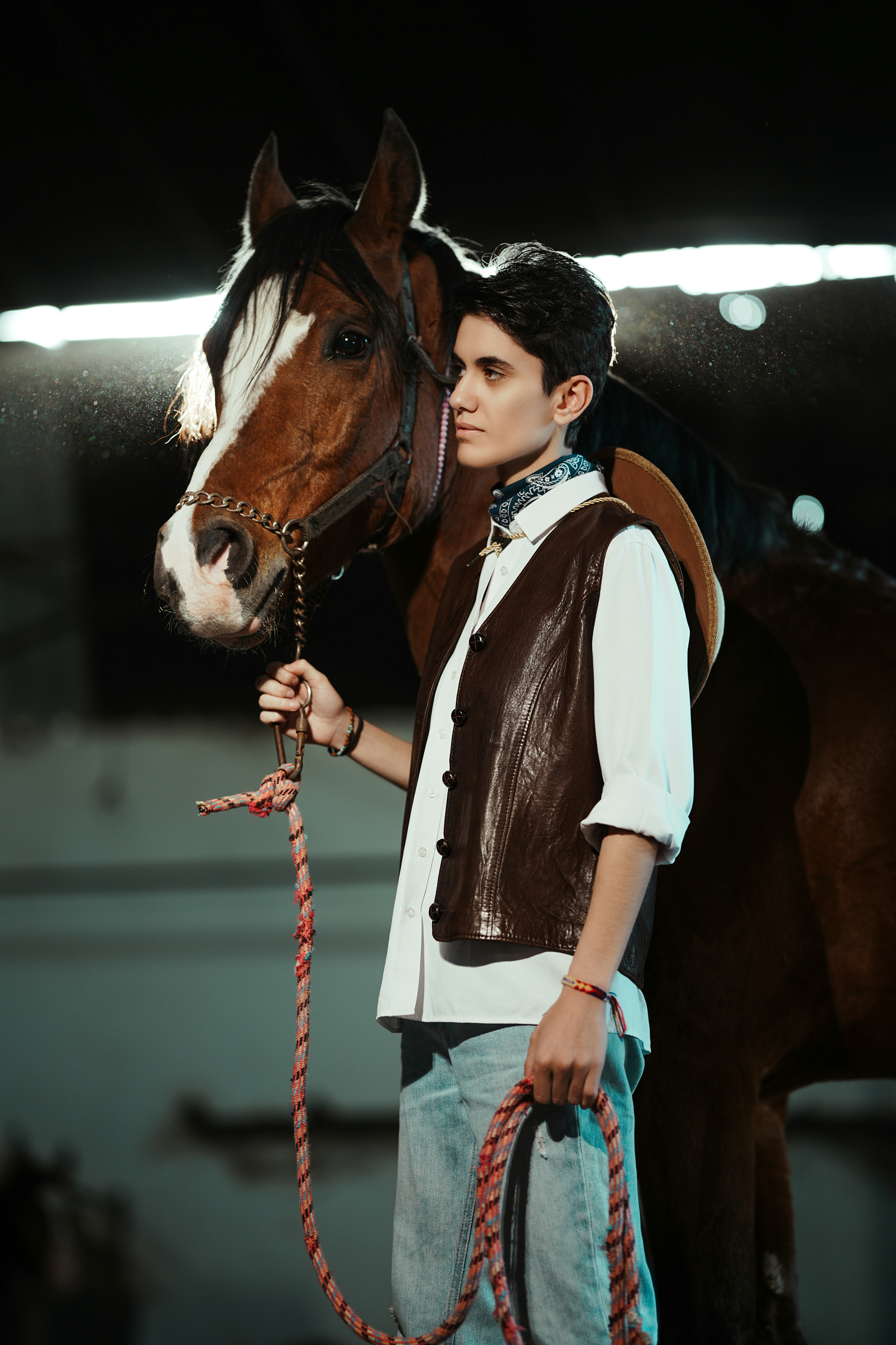Young person in western wear with a brown horse