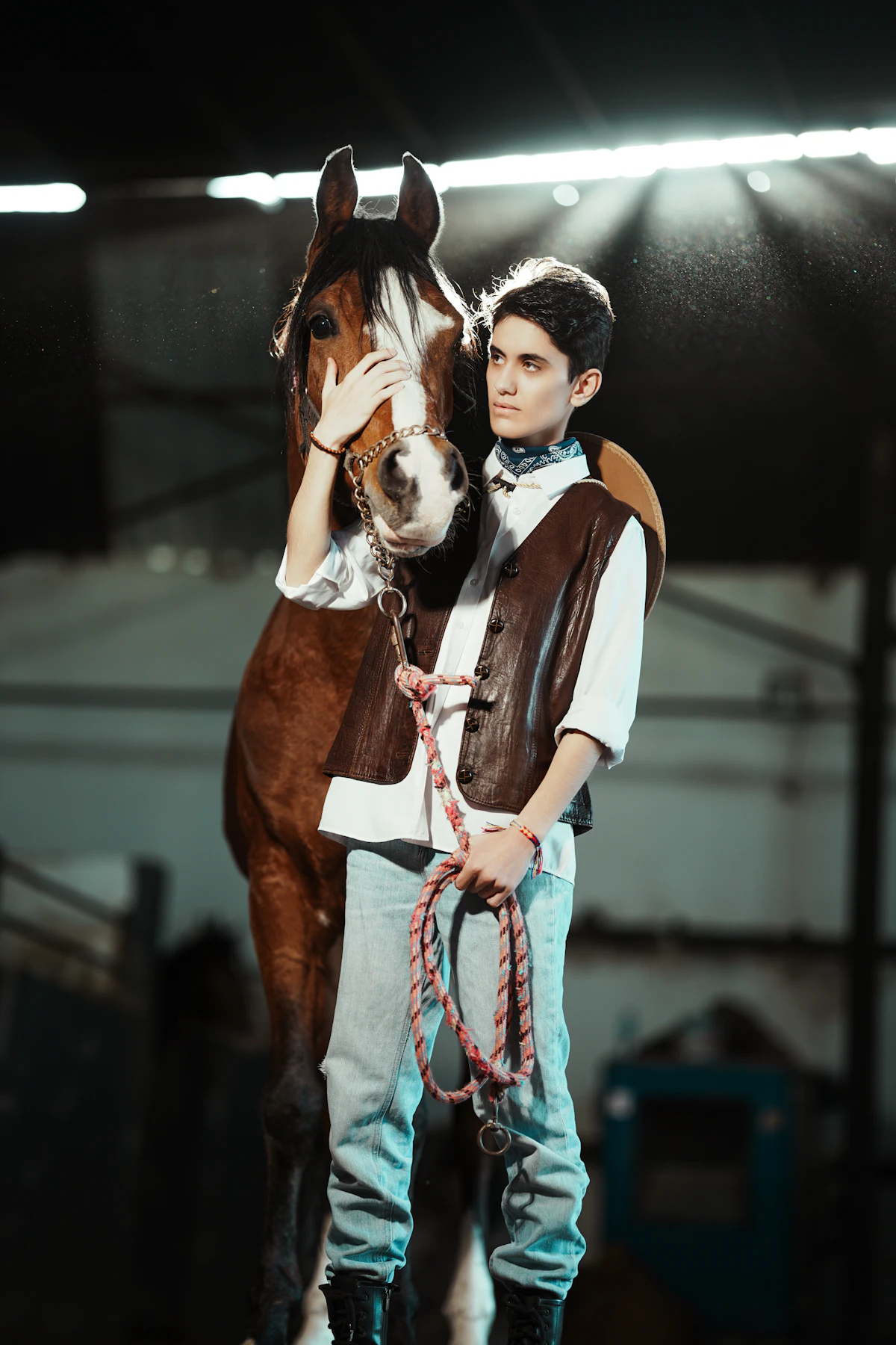 Horse and handler standing together inside a stable