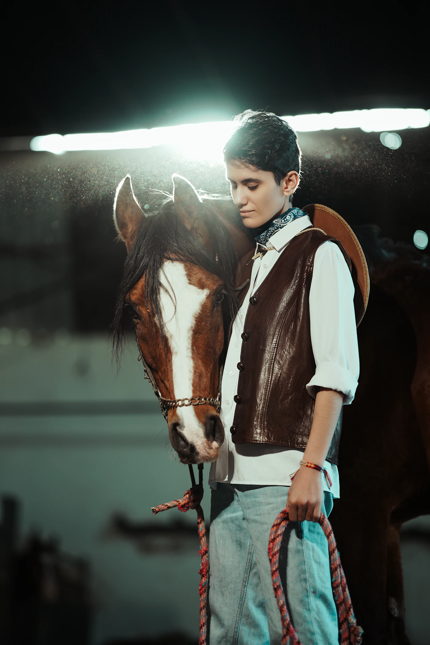 Handler leading a horse along a stable aisle