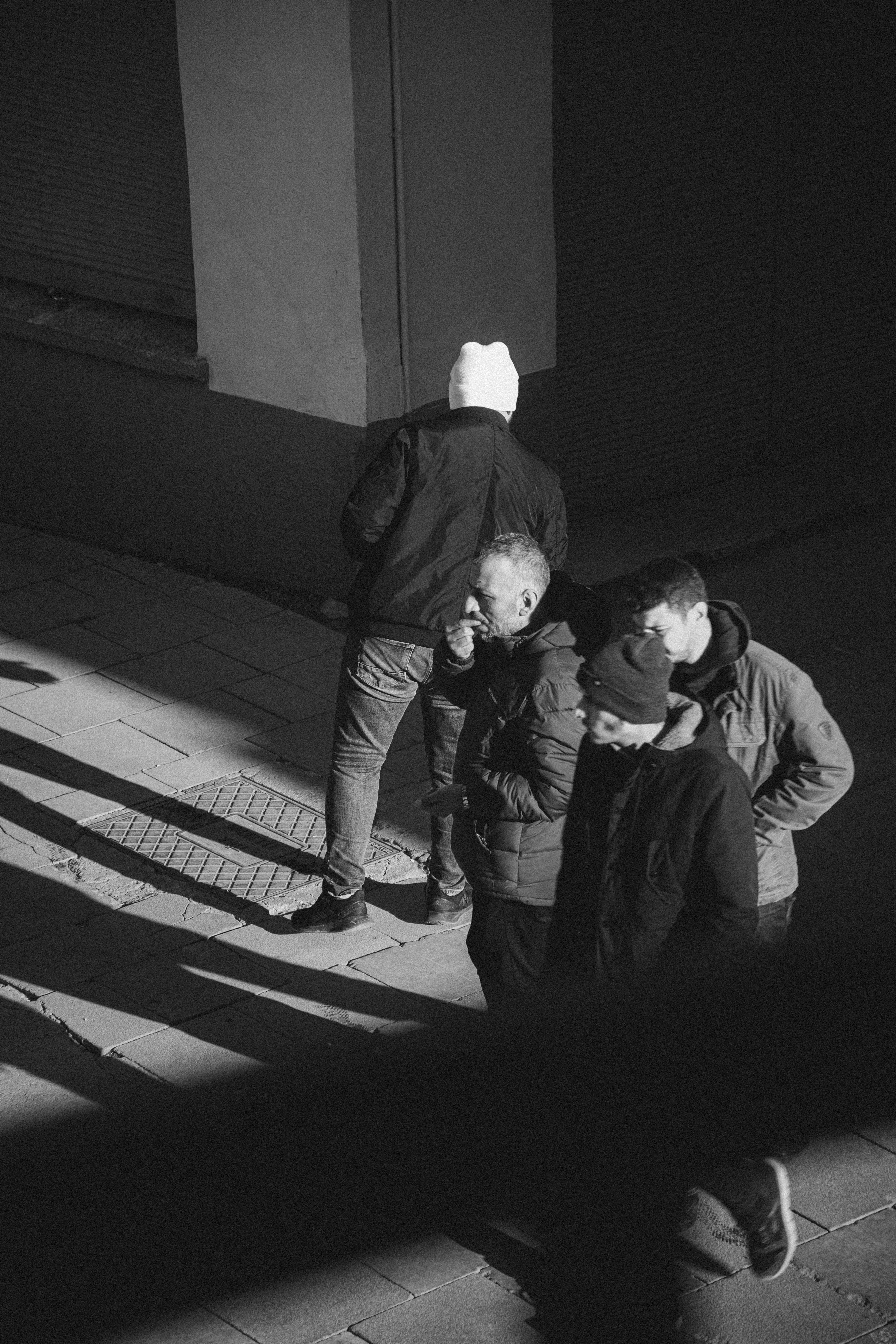 Four men walking together at night on a street.