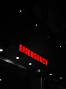 Red emergency sign illuminates a dark building entrance.