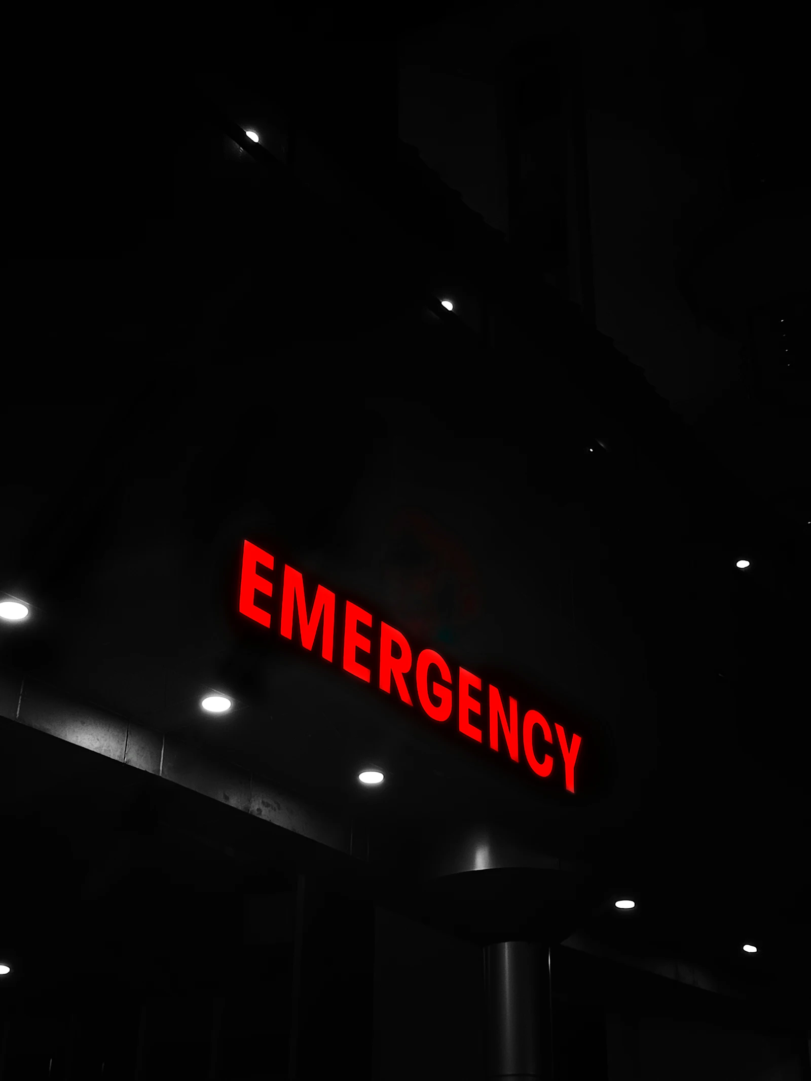 Illuminated red emergency sign above a hospital entrance