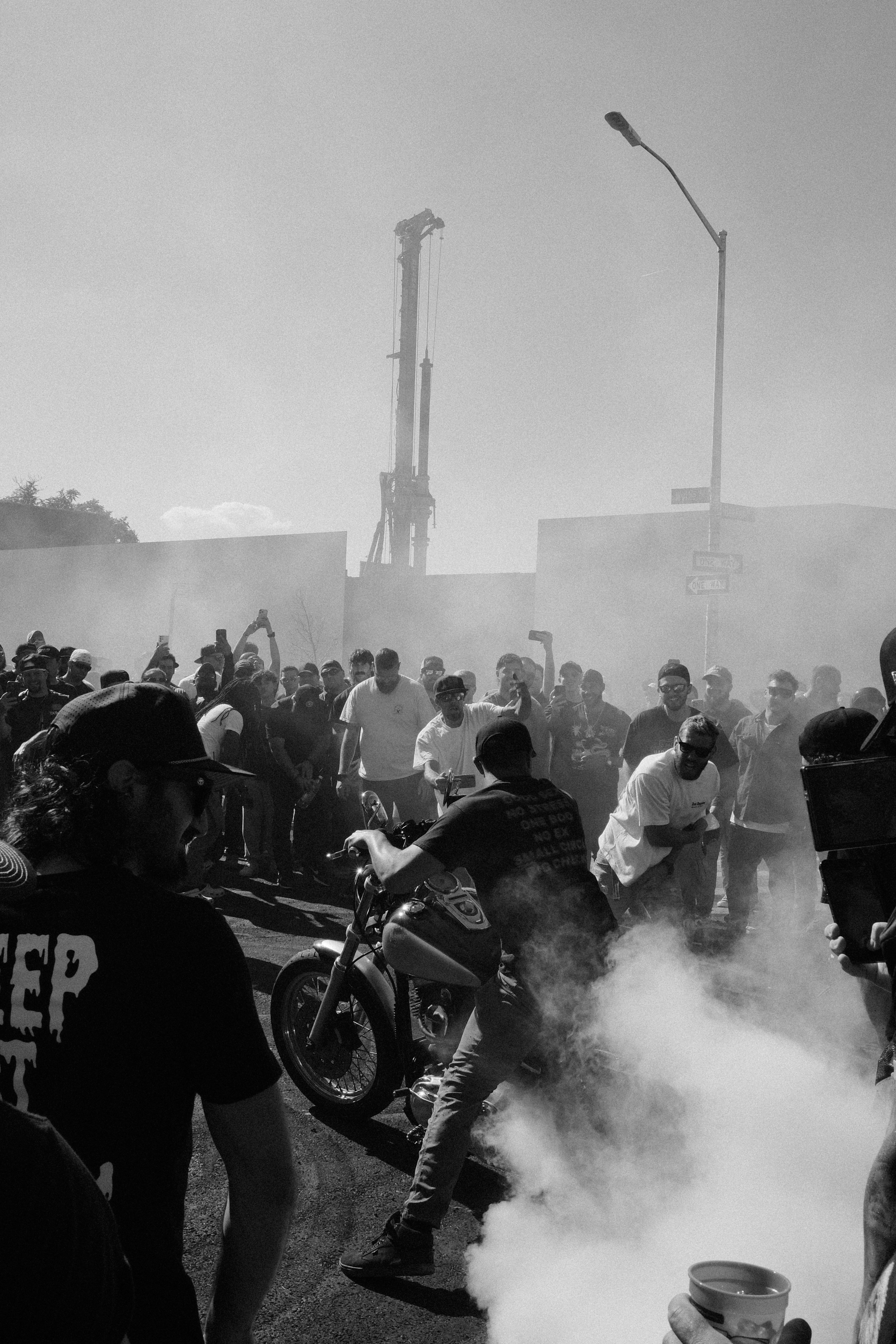 Motorcyclist performs burnout surrounded by crowd