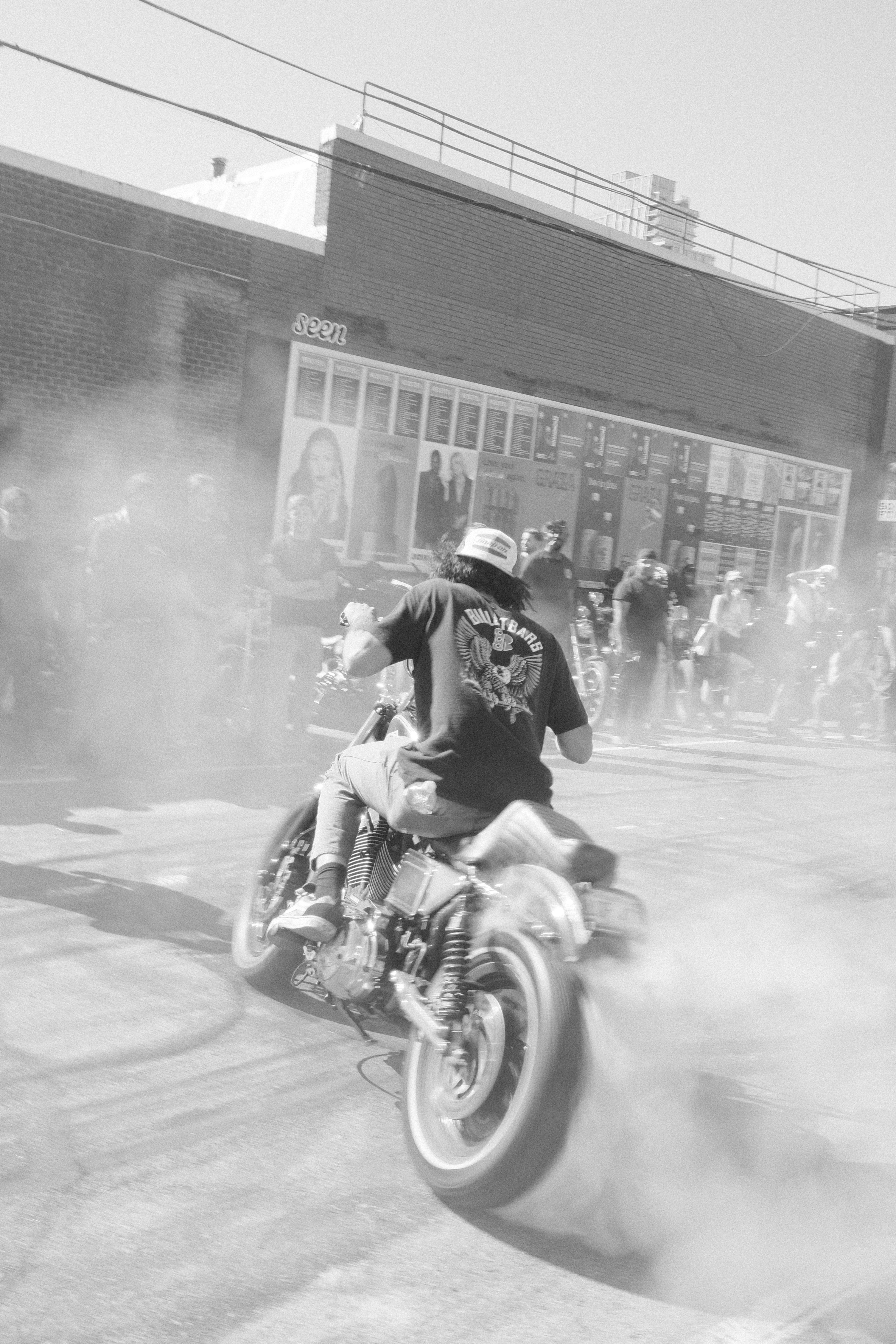Motorcyclist performing a burnout in smoky street.