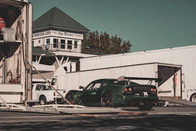 Green race car being unloaded from trailer