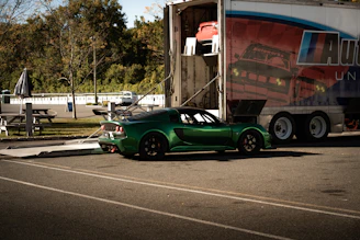 Green sports car being loaded into a trailer.