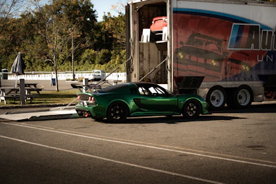 Green sports car being loaded into a trailer.