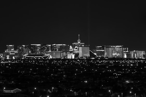 City skyline illuminated at night with distant lights.
