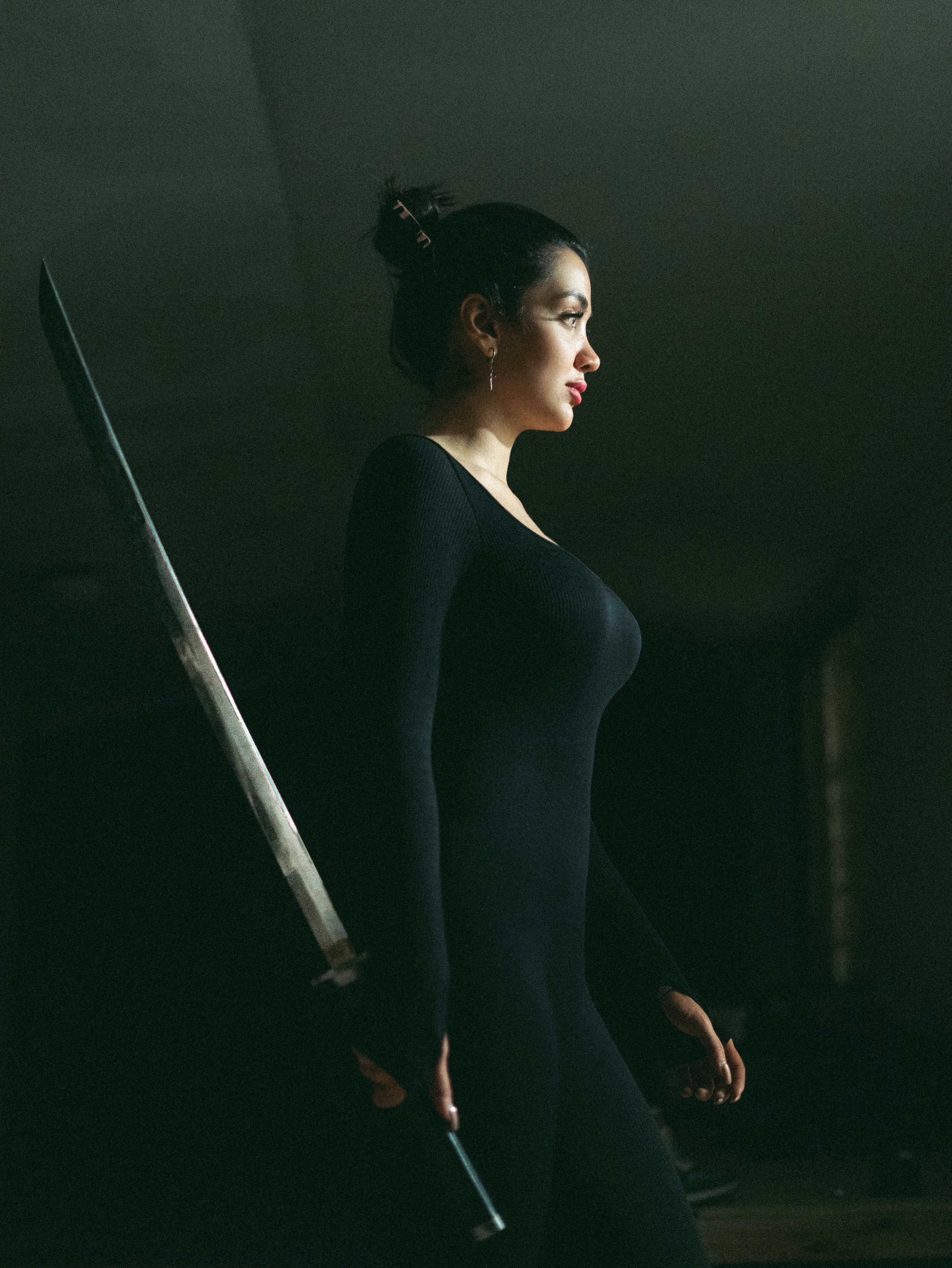 Woman in black dress holding a sword