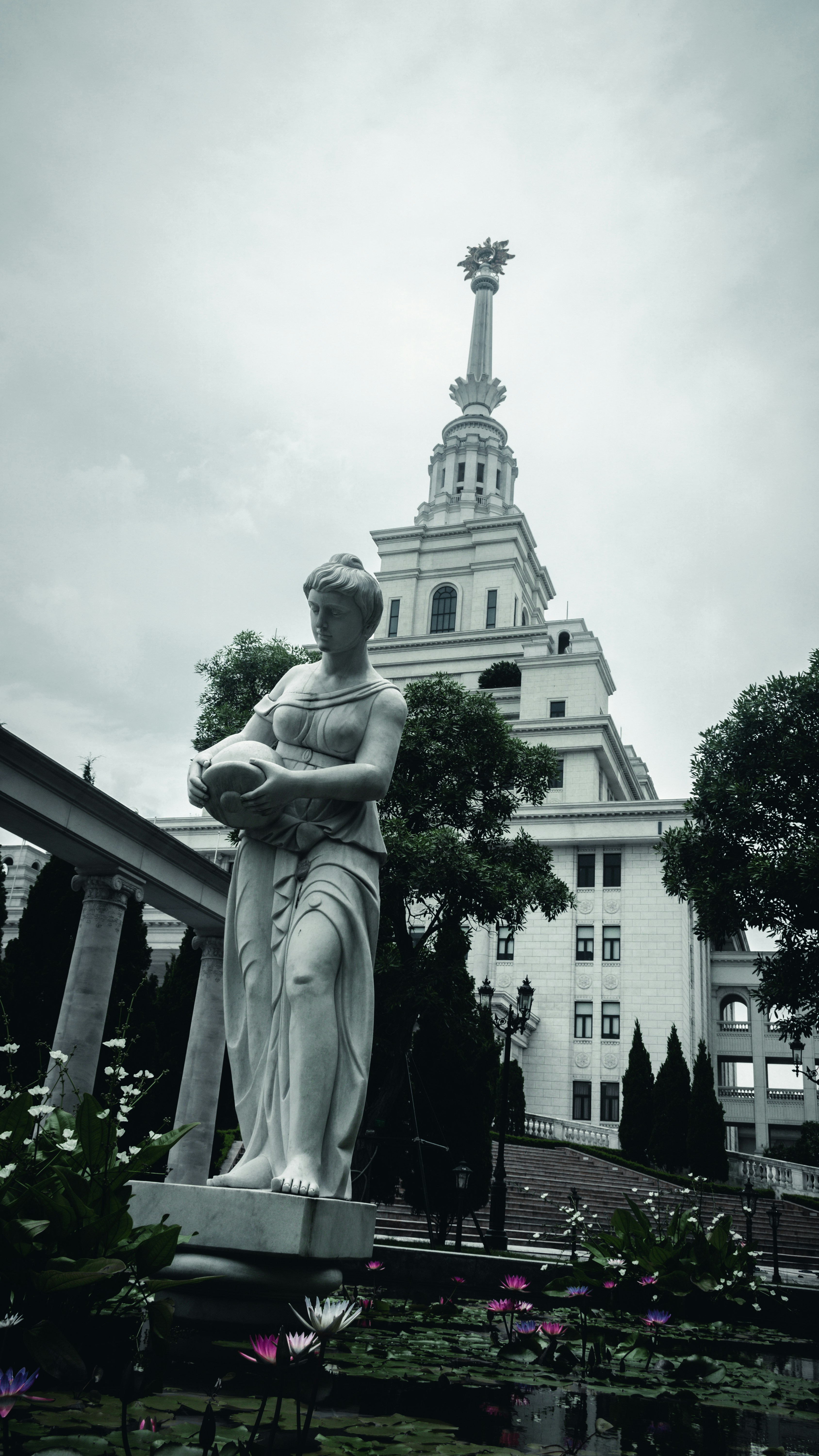 Statue in front of a grand building with a tower.