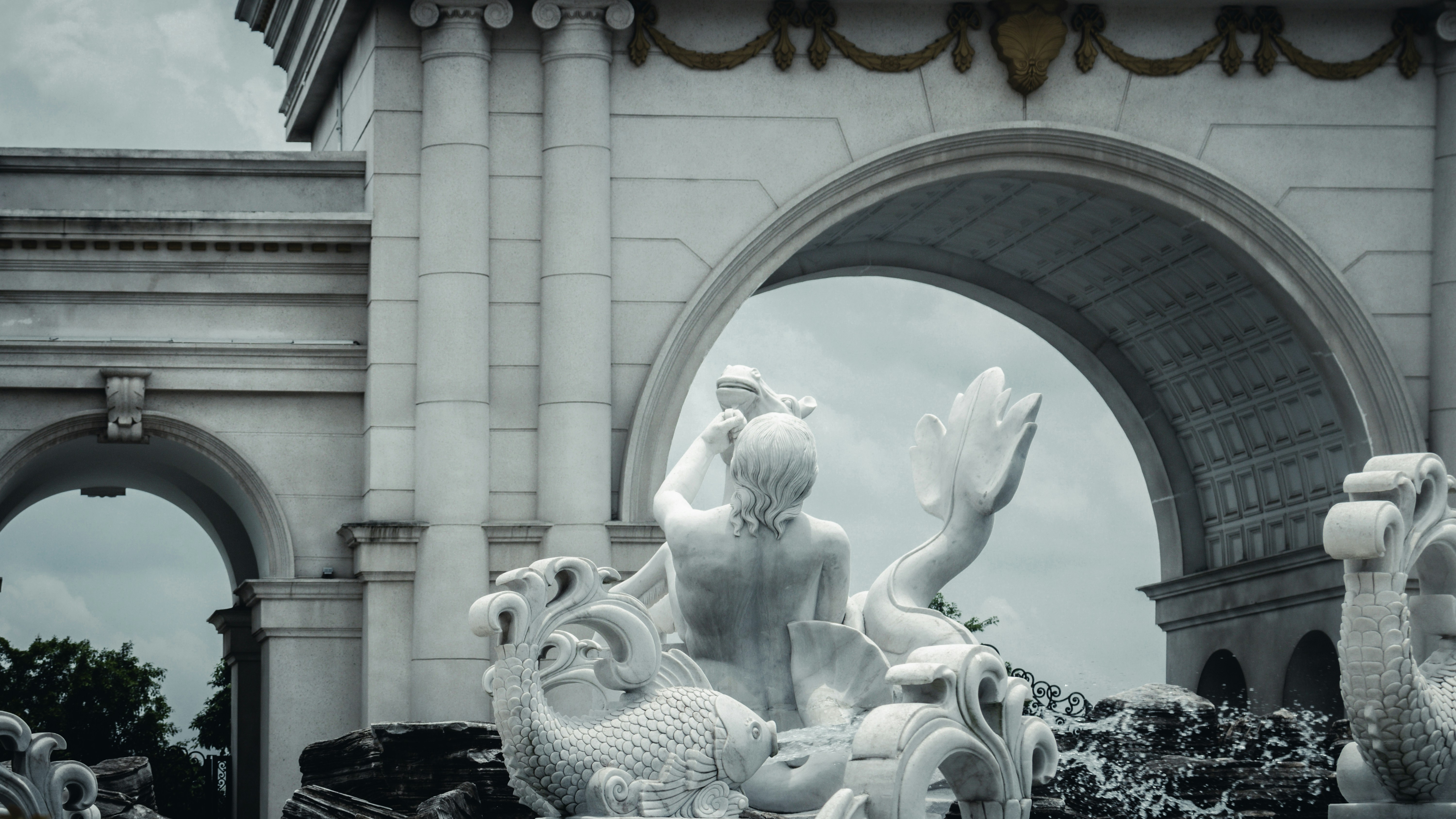 White marble sculpture of a mermaid and sea creatures.