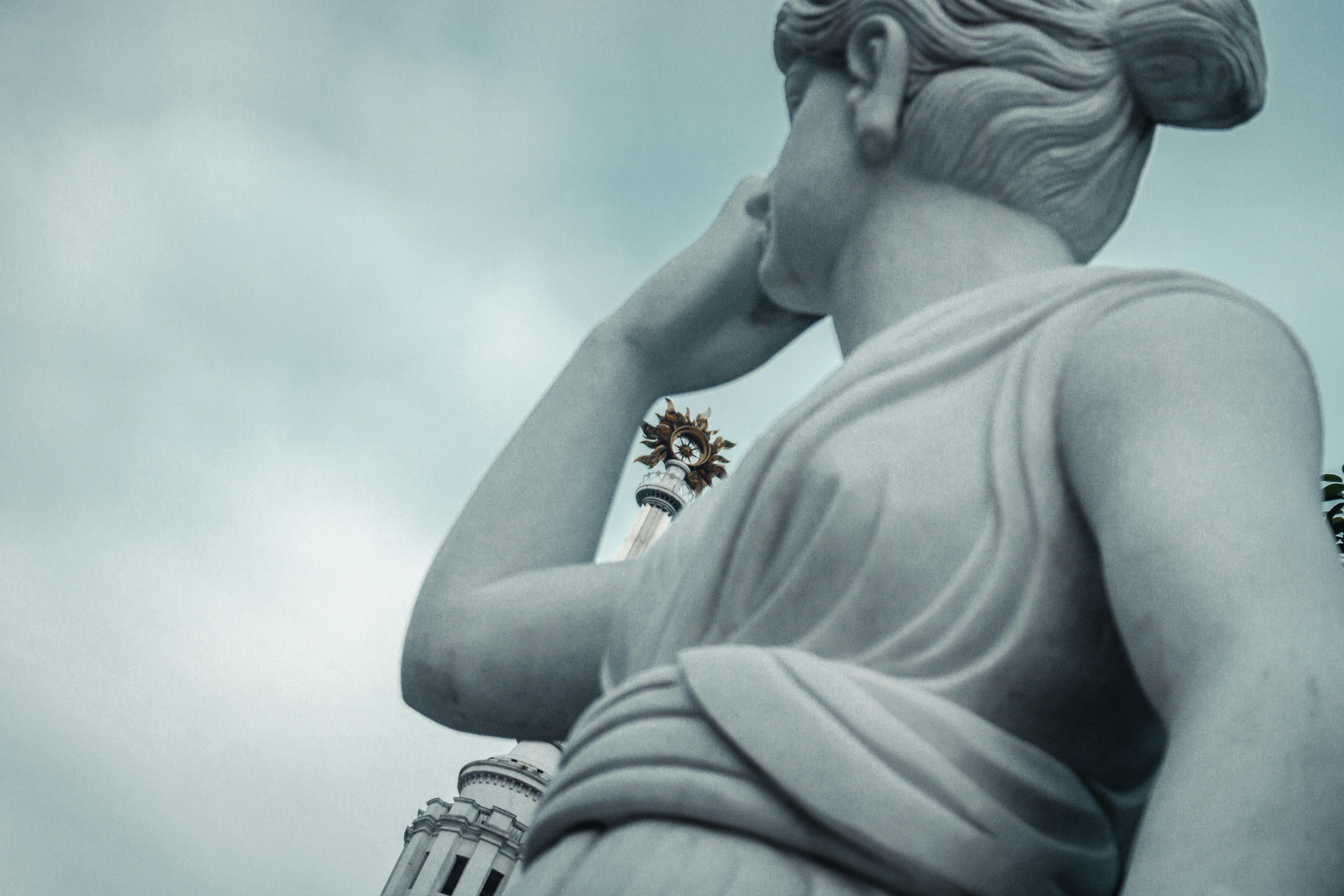 Marble statue of a woman against cloudy sky