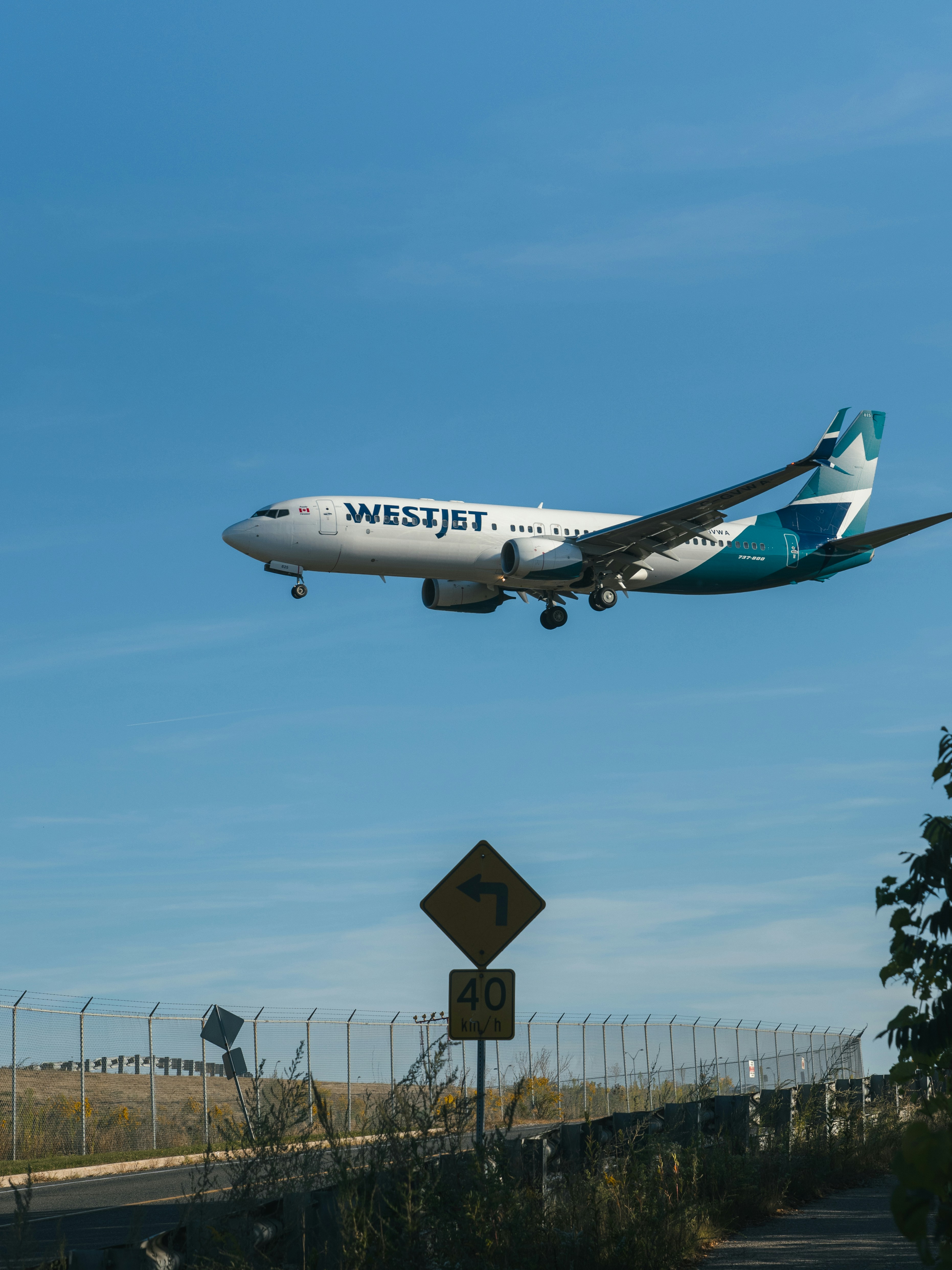 Westjet airplane flying in a clear blue sky.