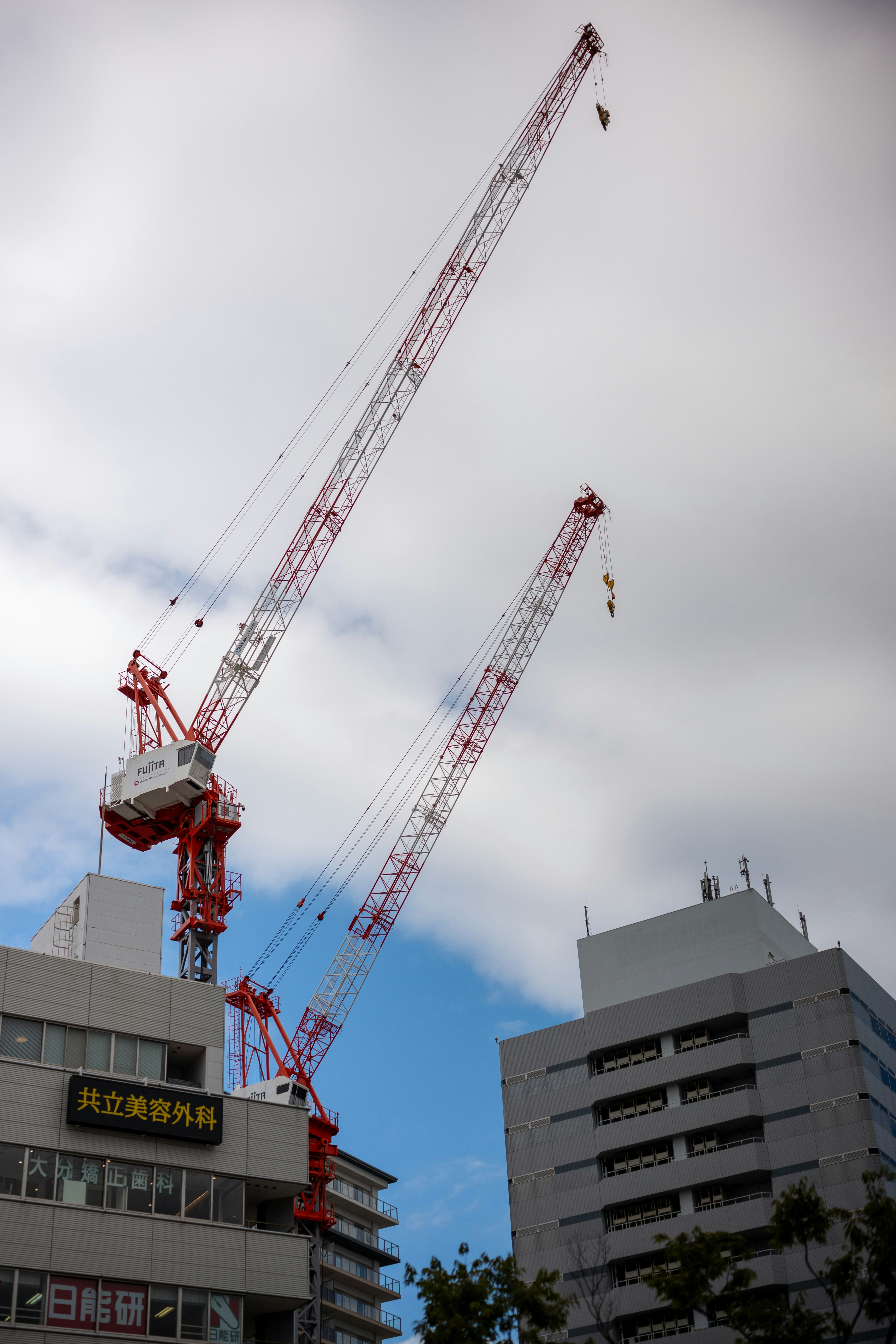 Zwei hohe Baukräne ragen über die Gebäude.