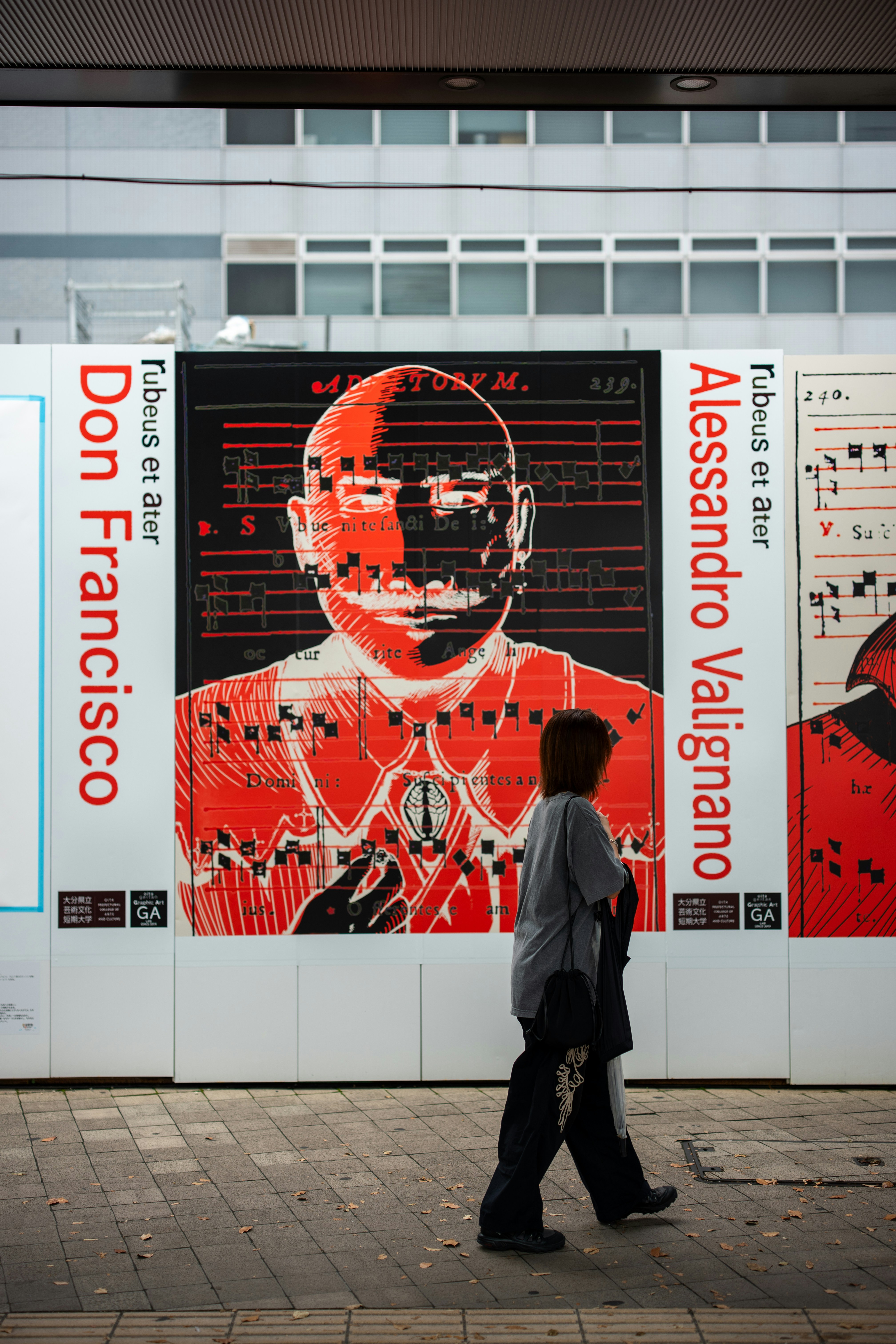 Person walks past large mural of a man's face