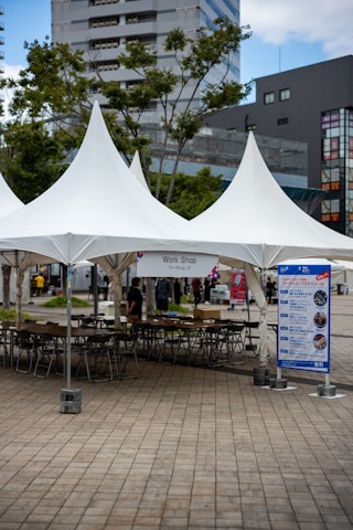 White tents set up for an outdoor workshop event.