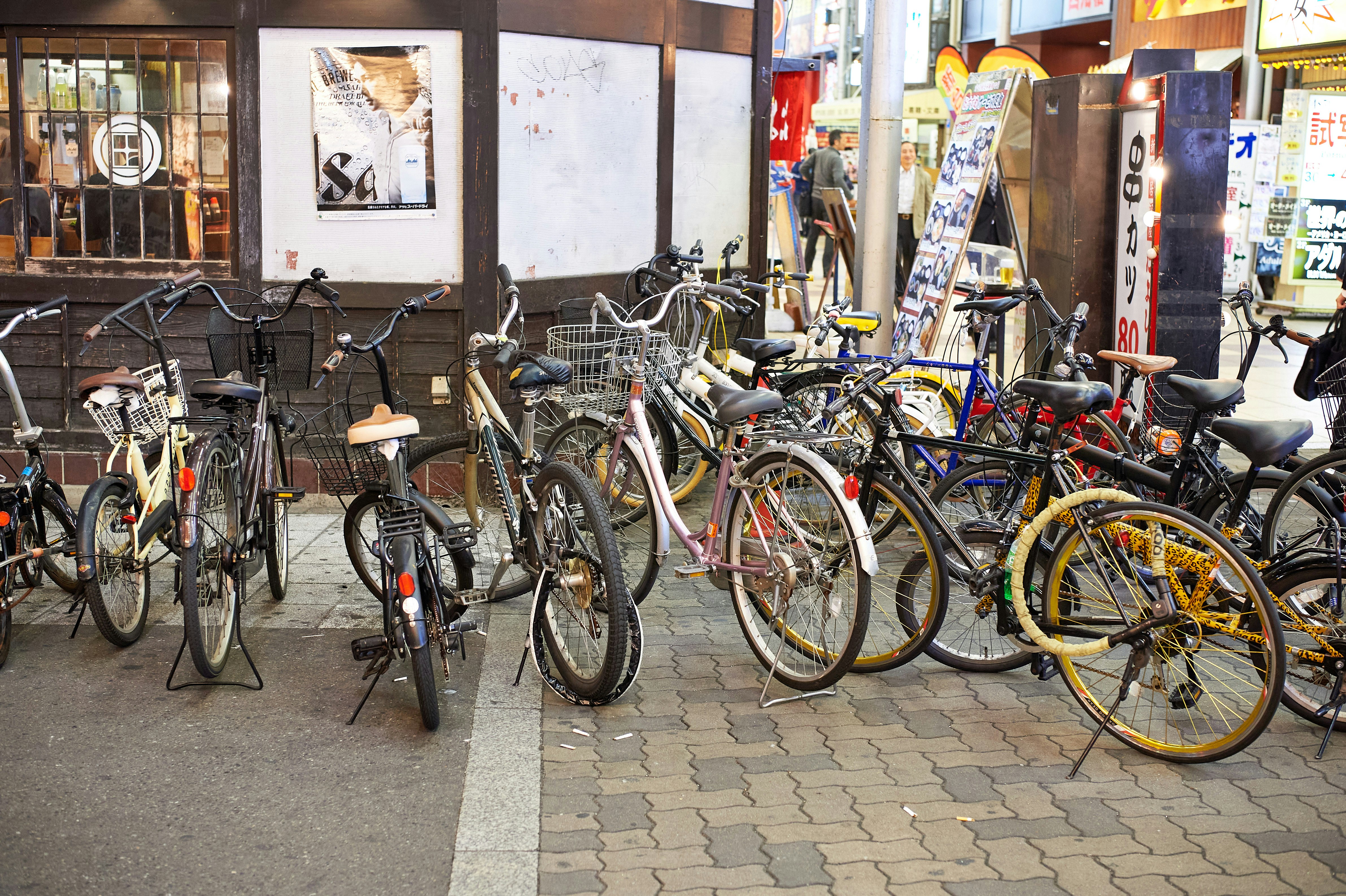 Bicycles parked on a city sidewalk at night.