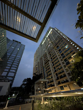 Tall apartment buildings at dusk with city lights.