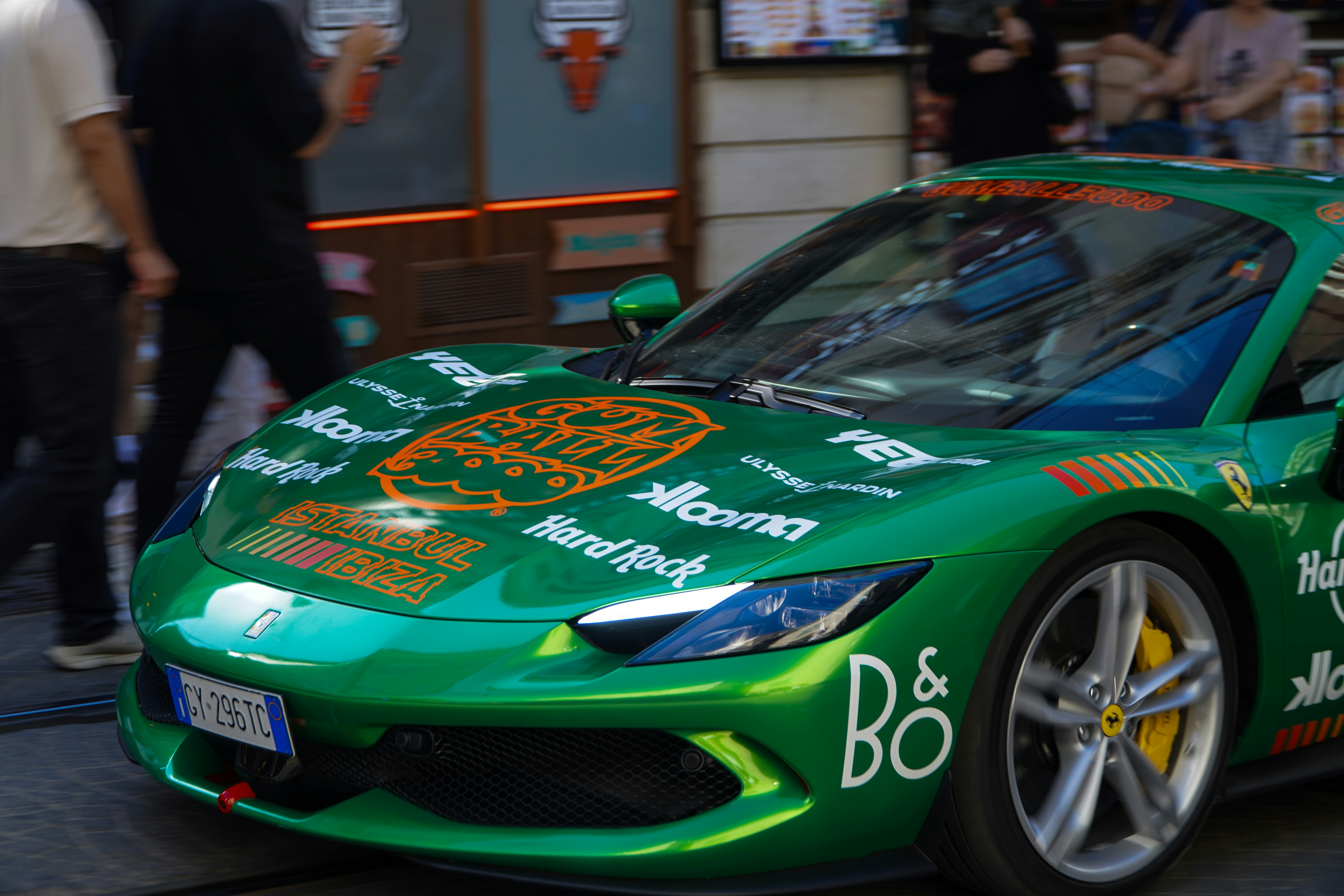 Green sports car with various sponsor stickers.