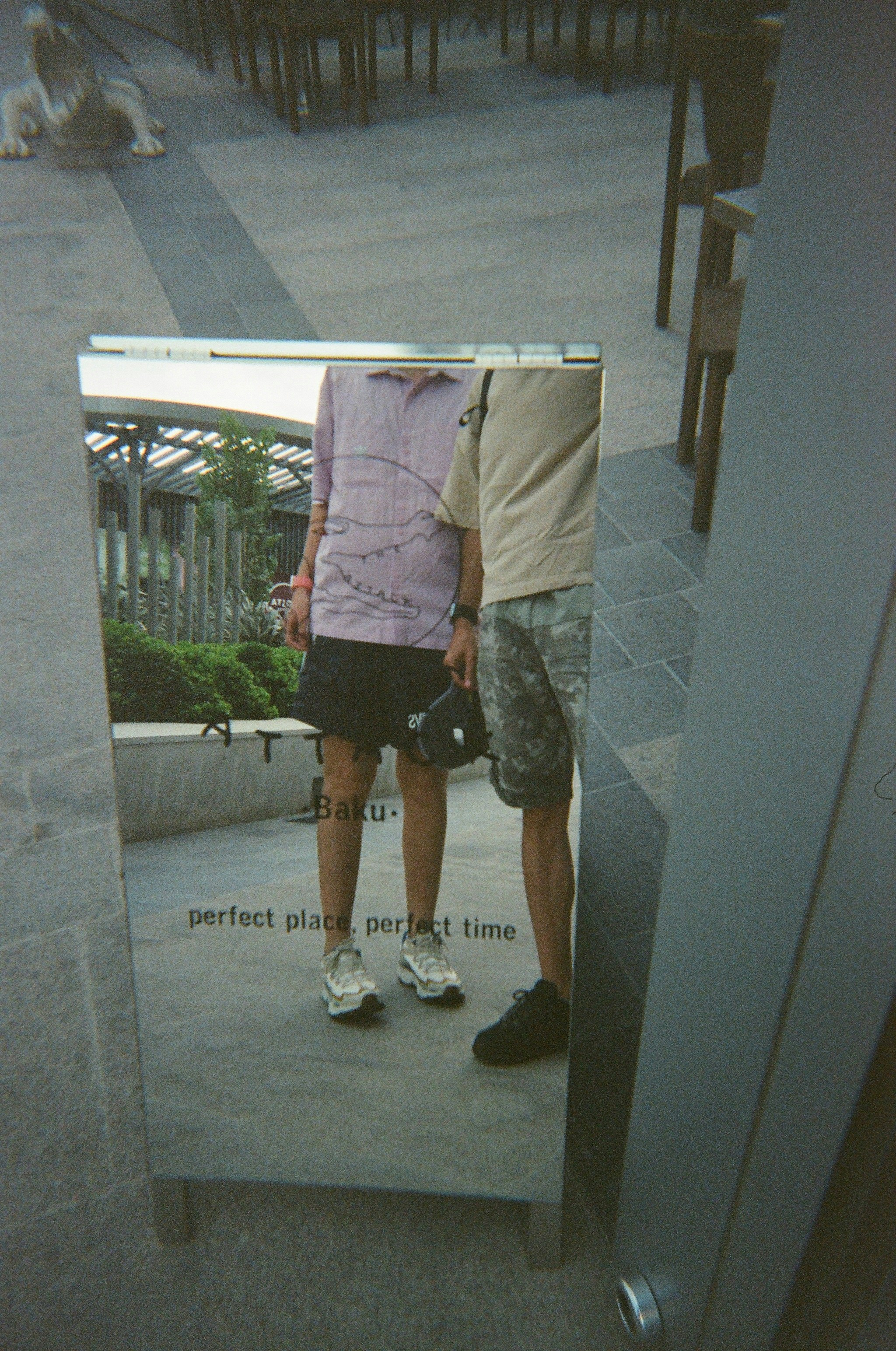 Two people reflected in a mirrored sign