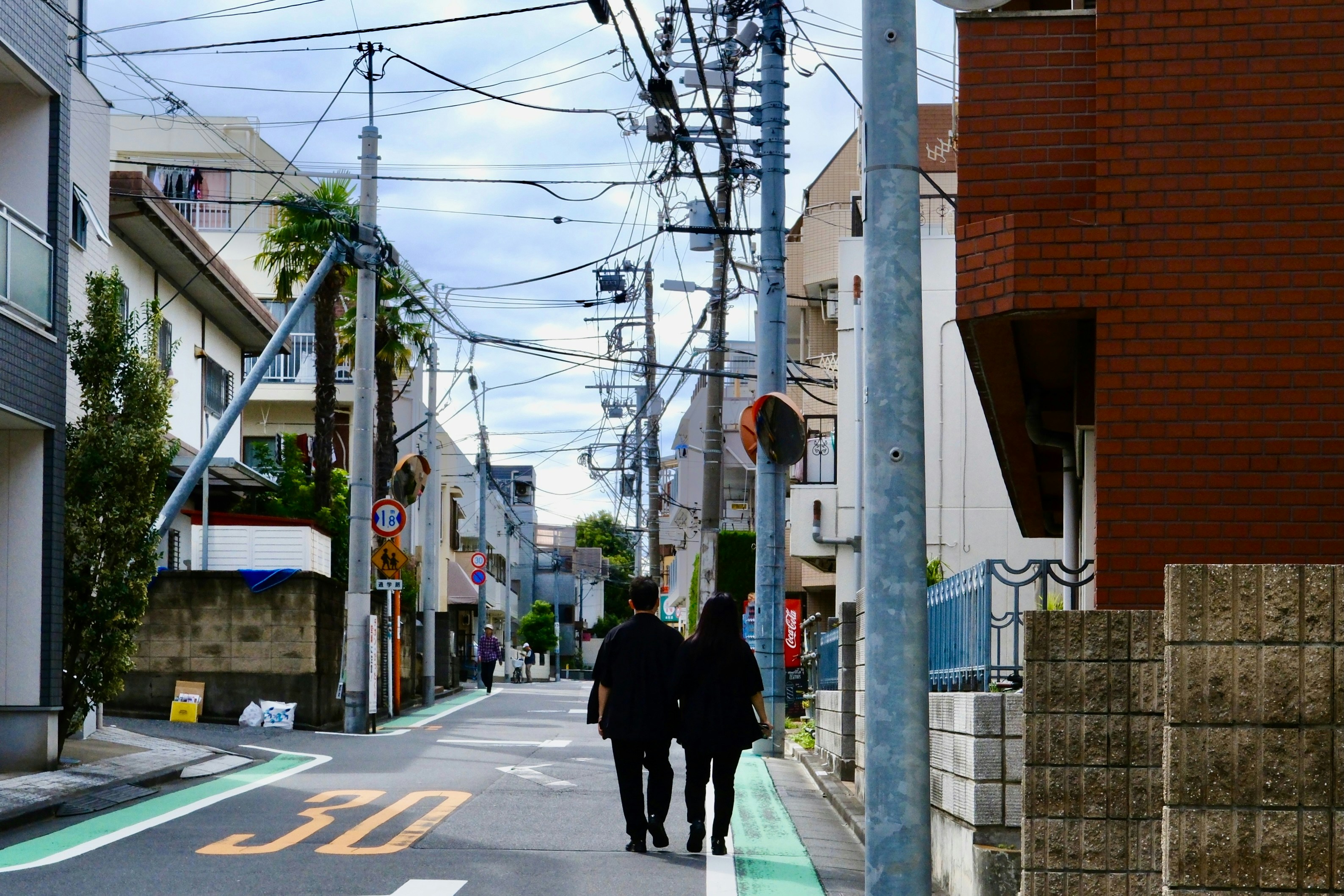 Two people walk down a quiet street.