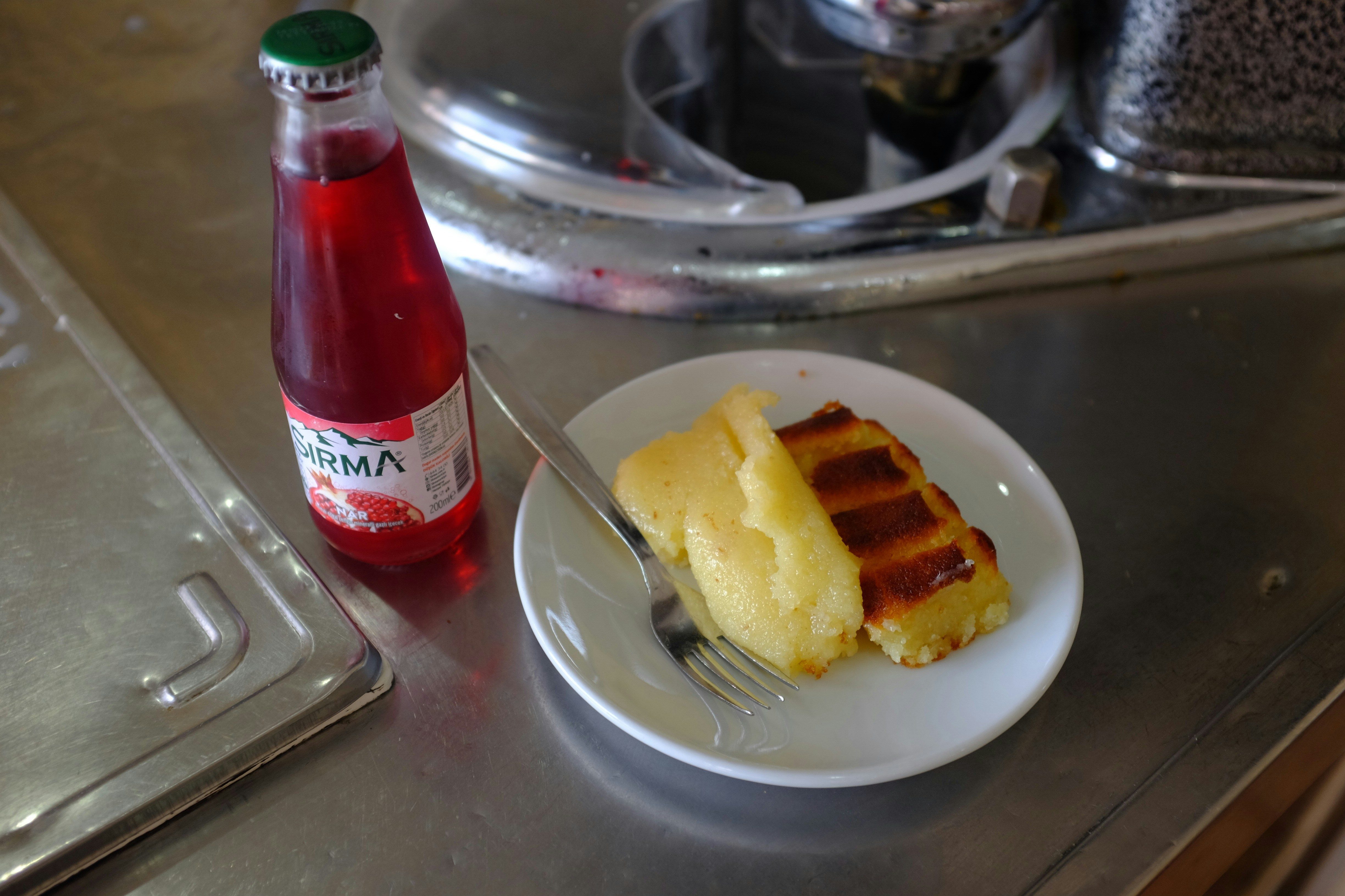 Stück Kuchen mit Vanillepudding und einem roten Getränk