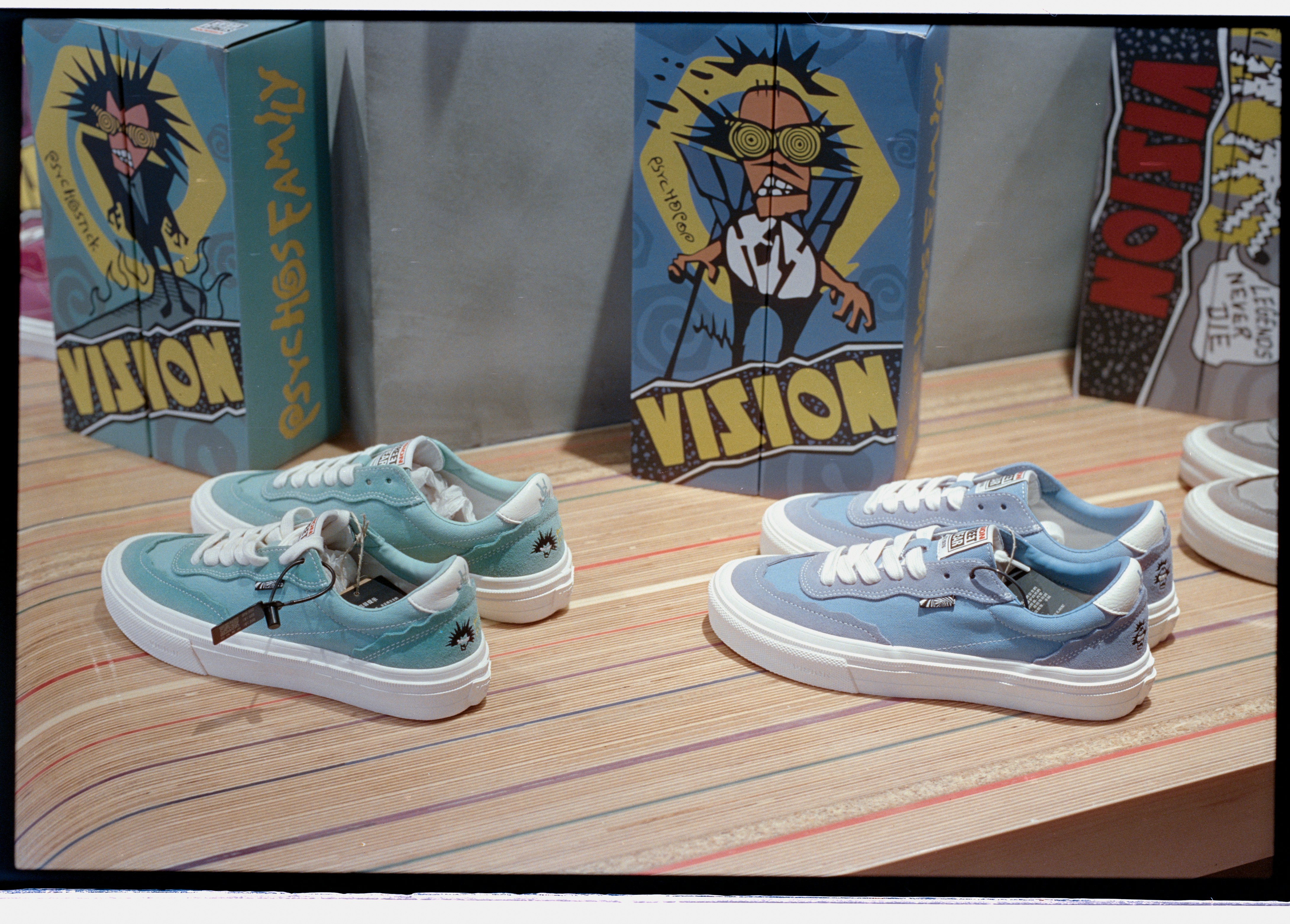Two pairs of blue sneakers with cartoon graphics.