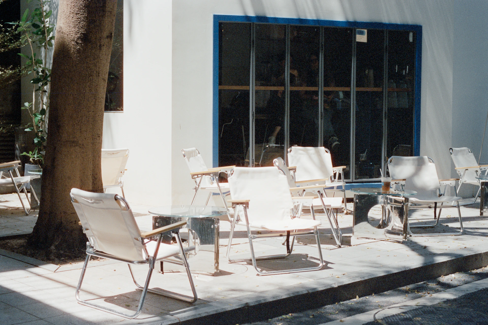 Outdoor seating area with white chairs and tables.