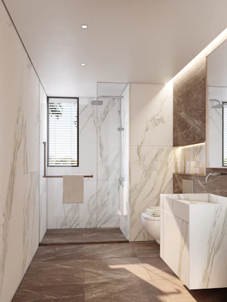 Modern bathroom with marble walls and sleek sink.