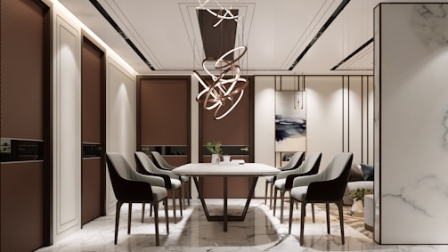 Modern dining room with elegant chairs and chandelier.