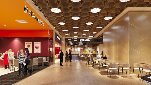 People walking through a modern shopping mall interior.