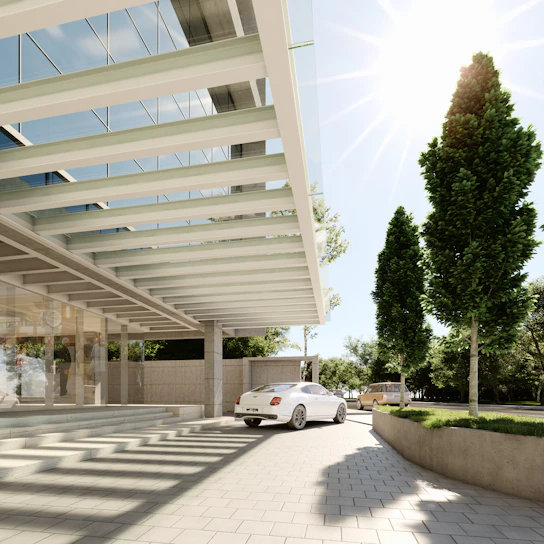 Modern building entrance with a white car arriving.